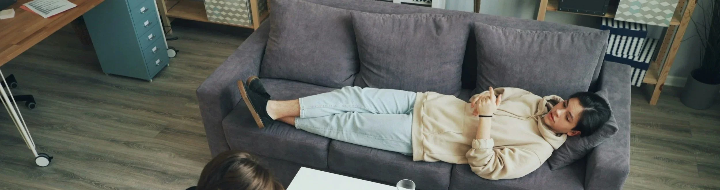 Person lying on a couch in an office