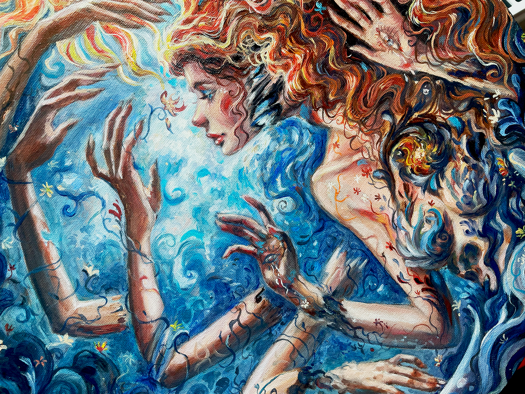 A painting of two women with flowing curly hair, surrounded by swirling blue patterns. One woman has brown hair with colorful highlights, and the other has dark hair with a golden swirl. They are close together, with one touching the other's face and