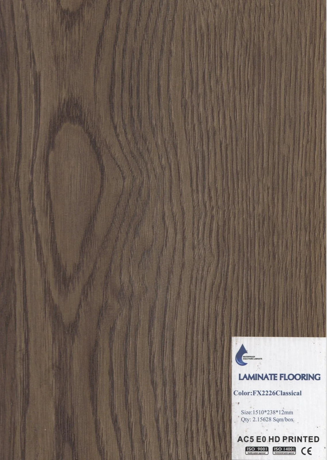 A sheet of laminate flooring with a wood grain pattern in brown tones, labeled as 'LAMINATE FLOORING' with product details on a white sticker in the bottom right corner.
