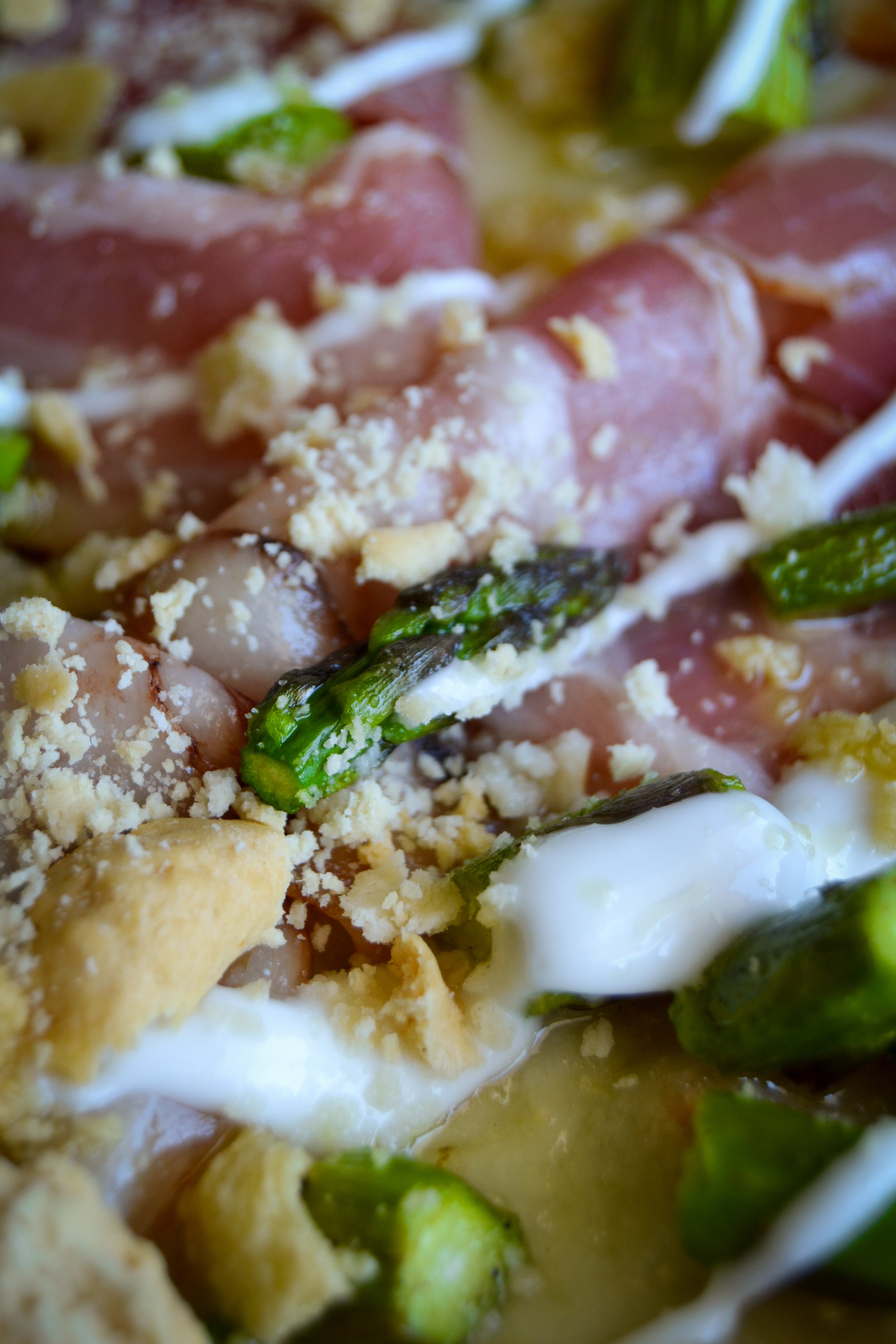 Dettaglio di una pizza con peperoni verdi, uova, formaggio e prosciutto cotto.