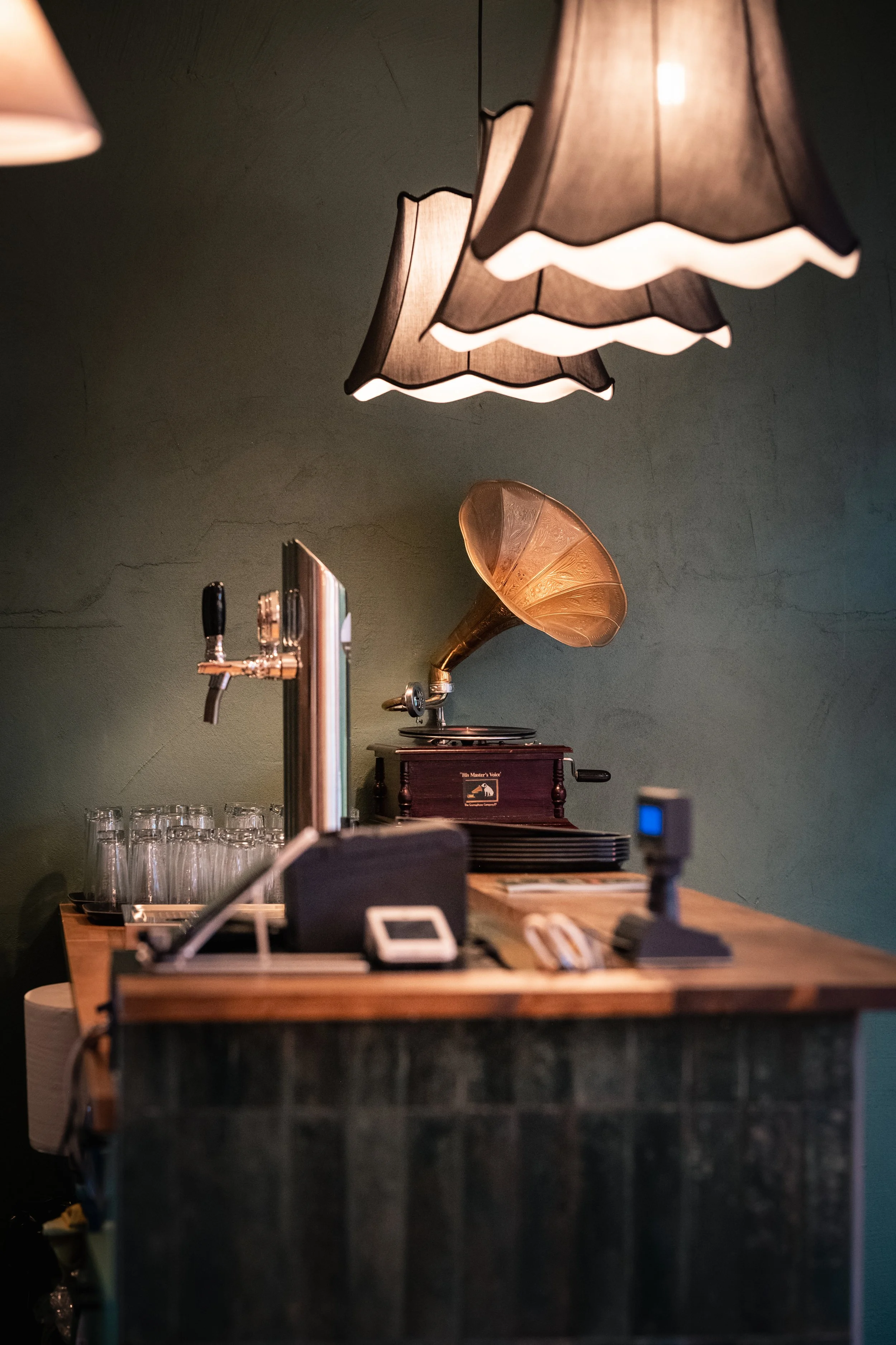 Bar con lampade a soffitto e una vecchia grammofono sul bancone.