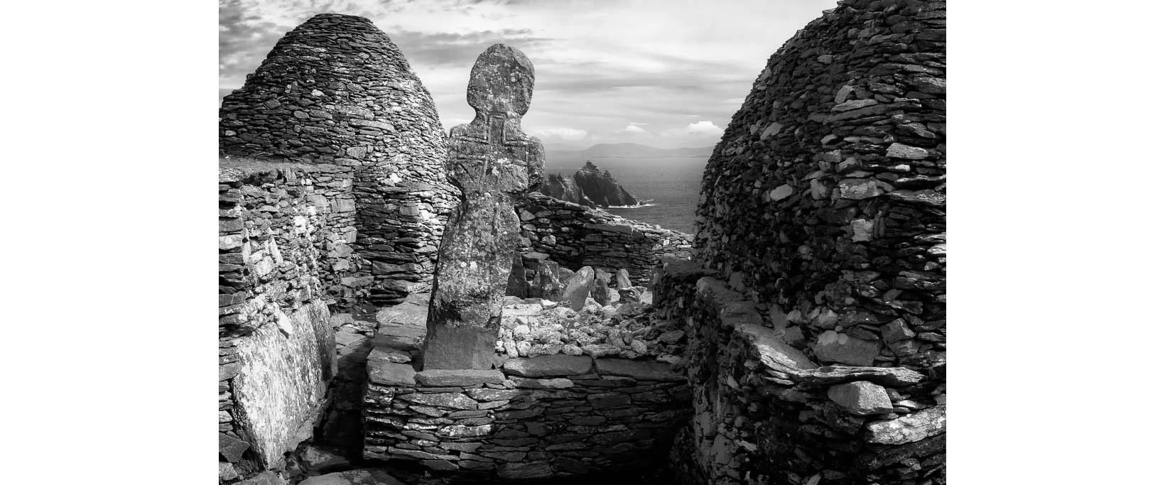 Black and white photograph of the Priest's Stone Cross in the Skellig Michael graveyard, County Kerry, Ireland by Bret Culp, featured in the testimonials section on the homepage.
