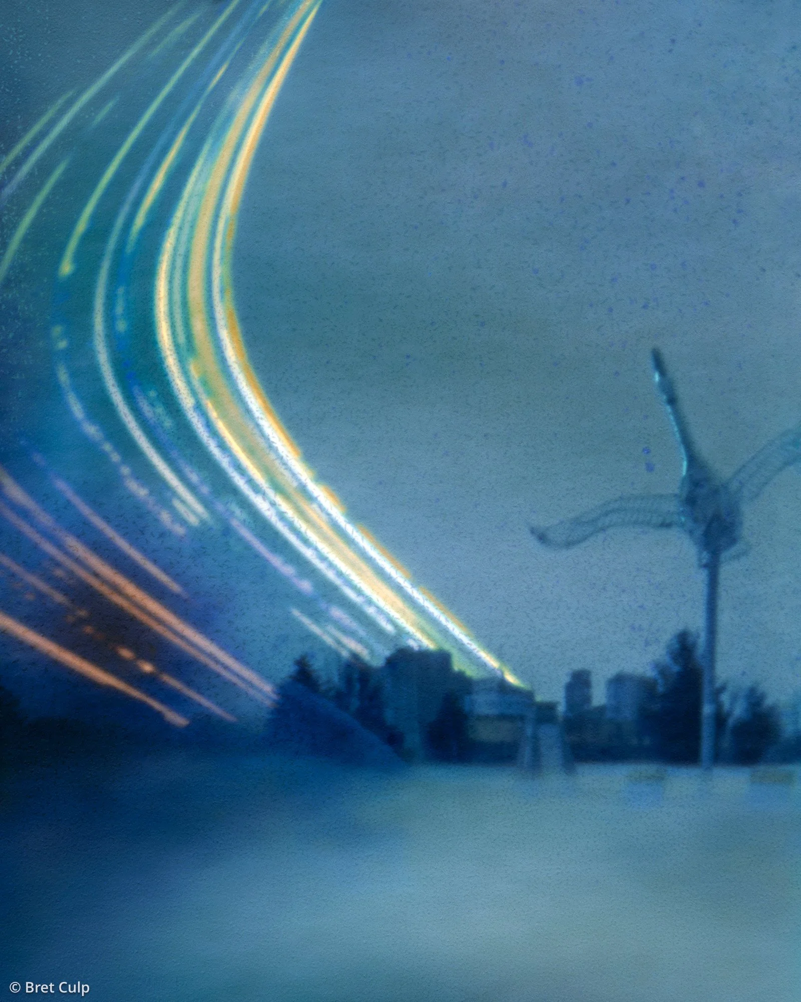 87‑day solargraph tracing sun arcs above Midland Harbour, Ontario, with silos, docks, winter trees and Ron Hunt’s trumpeter swan sculpture