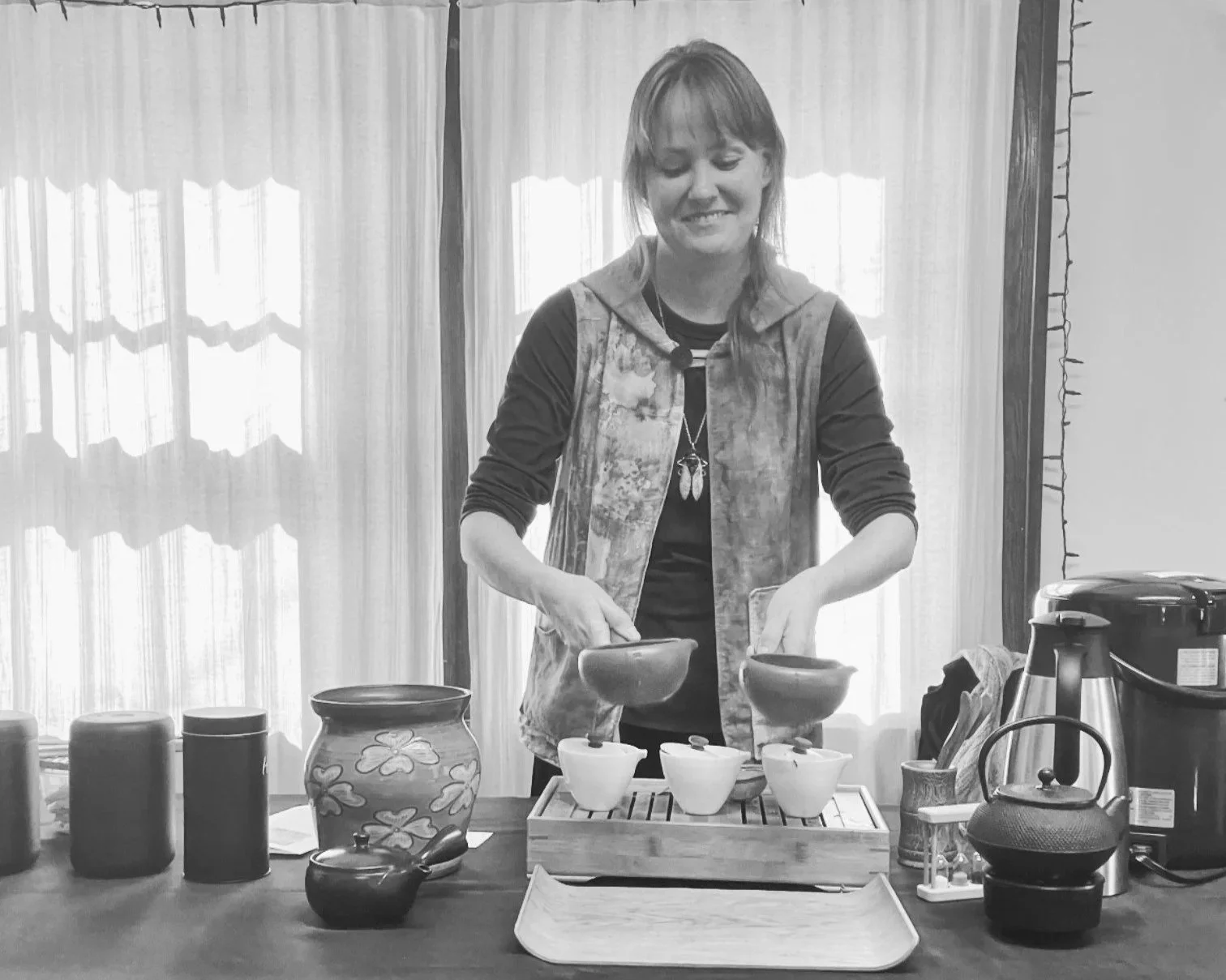 Owner Andrea Connolly preparing tea using gaiwan-style vessels for a tasting event.
