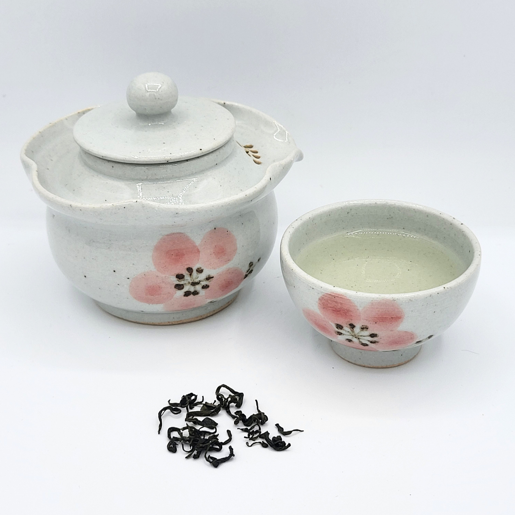 Korean-style gaiwan and cup with infused Woojeon tea and a small mound of loose leaf Woojeon in front.