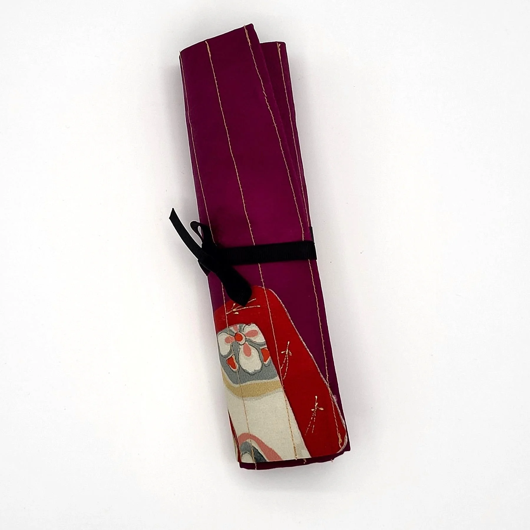 Rolled purple art utensil case tied with a black ribbon.