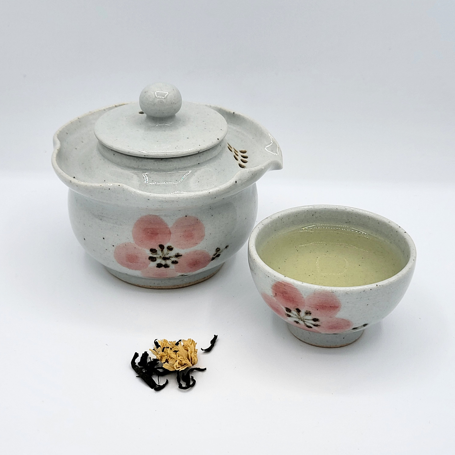 Korean-style gaiwan and cup of brewed Chrysanthemum Joonjak with mound of dried tea leaves in front.