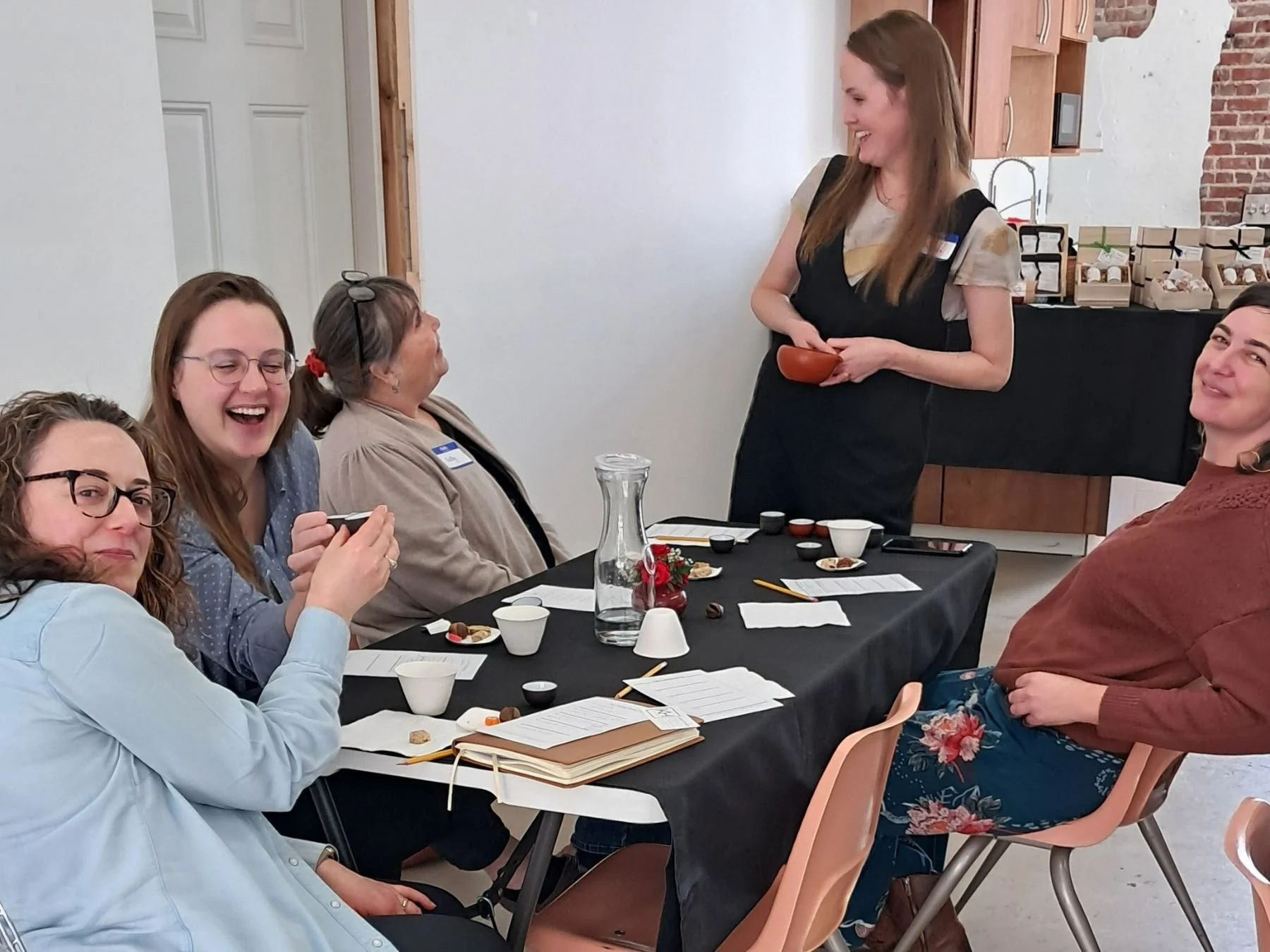 Andrea talking with seated guests at a tasting event.