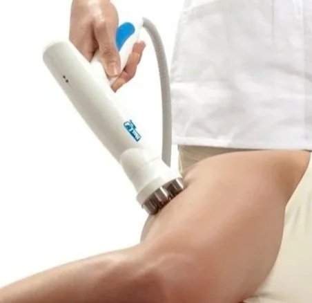 A healthcare professional uses a medical device on a patient's arm for a procedure, with a white and blue setting.