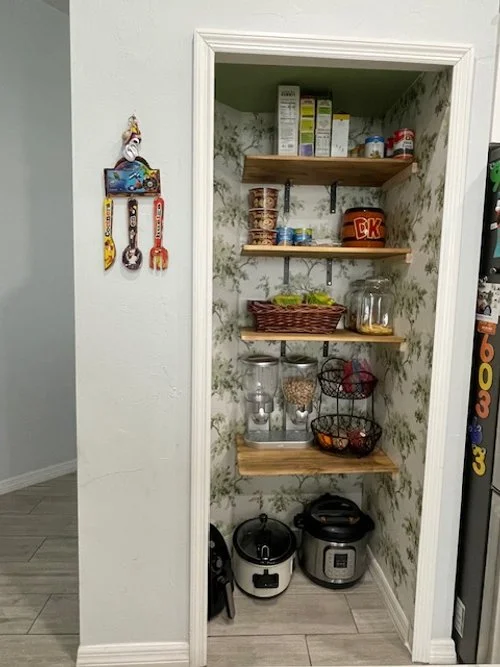 A lively wallpaper changed the mood of the pantry. New wood shelves with reworked spacing and anchored reinforcements now accommodates all the pantry items and appliances. Additionally, sensor lighting was placed to provide better clarity at night.