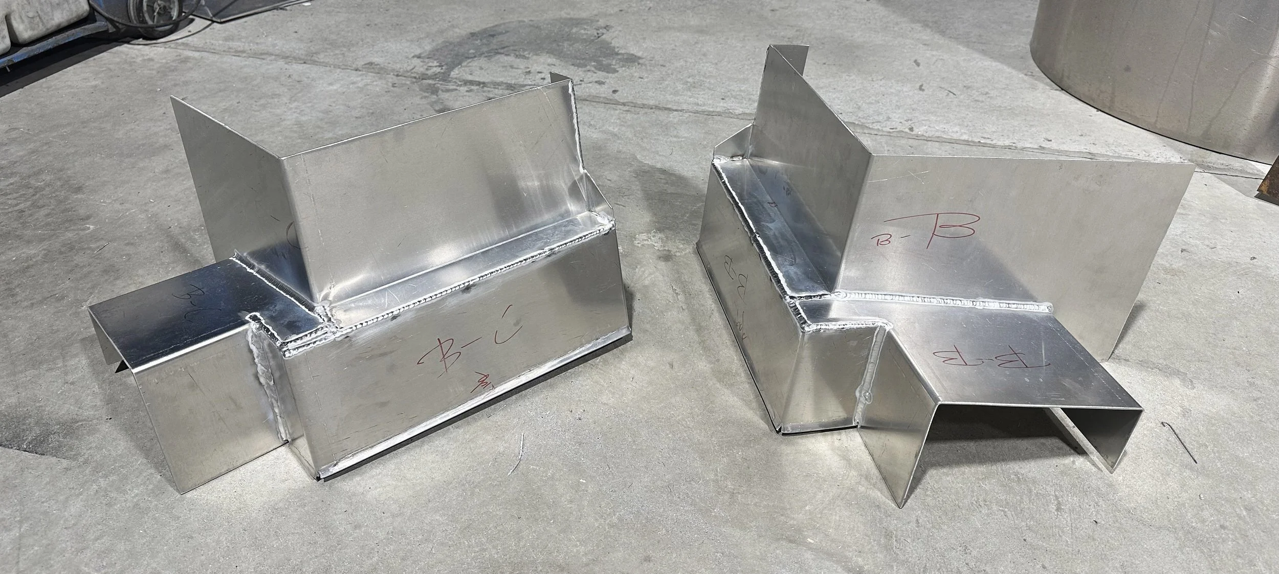 Two metal duct connectors on concrete floor