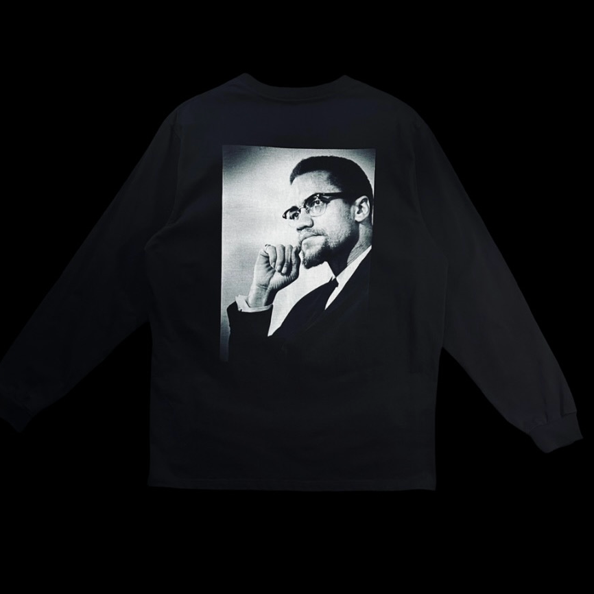 A black long-sleeve shirt with a black-and-white portrait of a man wearing glasses and a suit, posed with his hand under his chin, printed on the back.