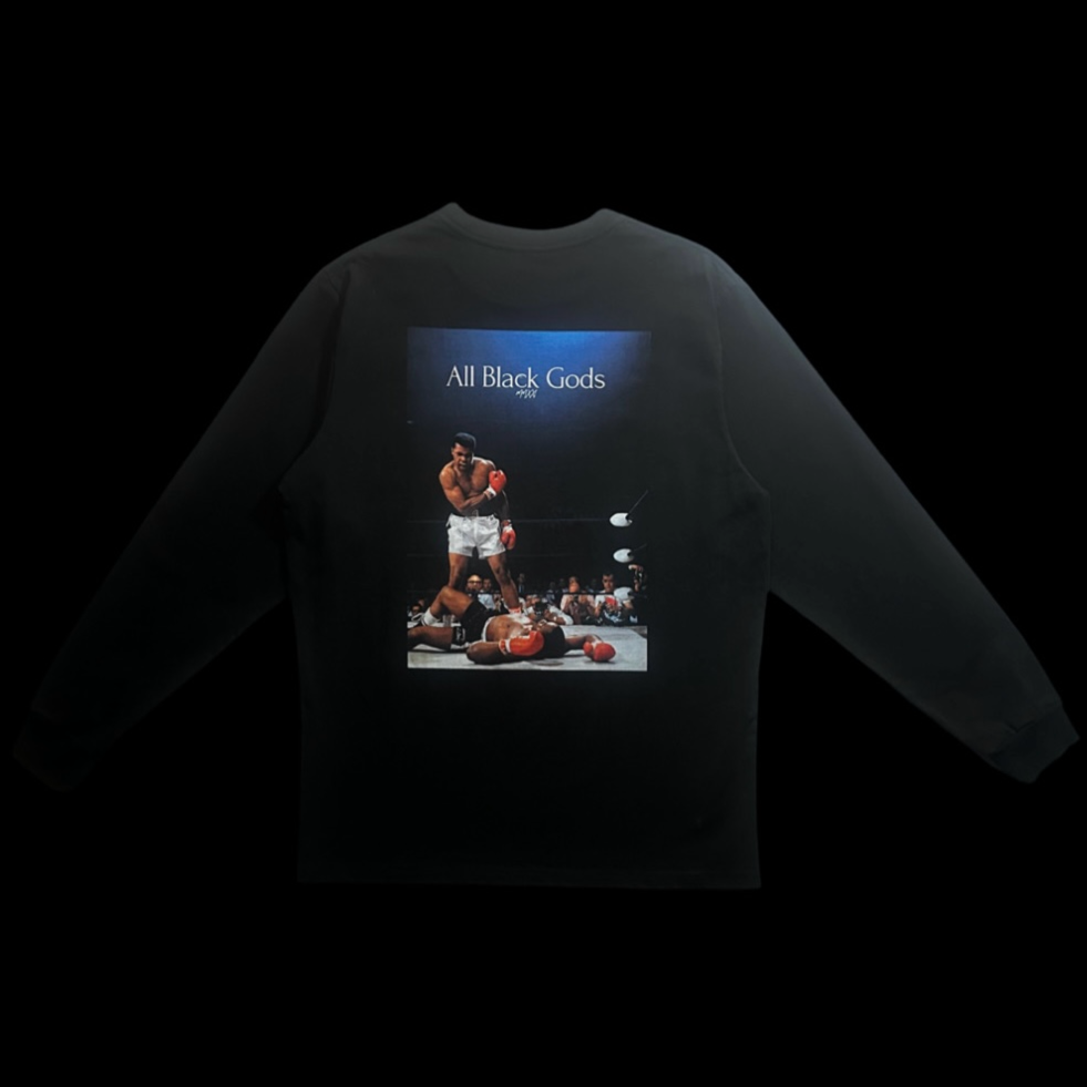 Black sweatshirt with a graphic of a boxing match and the text 'All Black Gods' on the back.