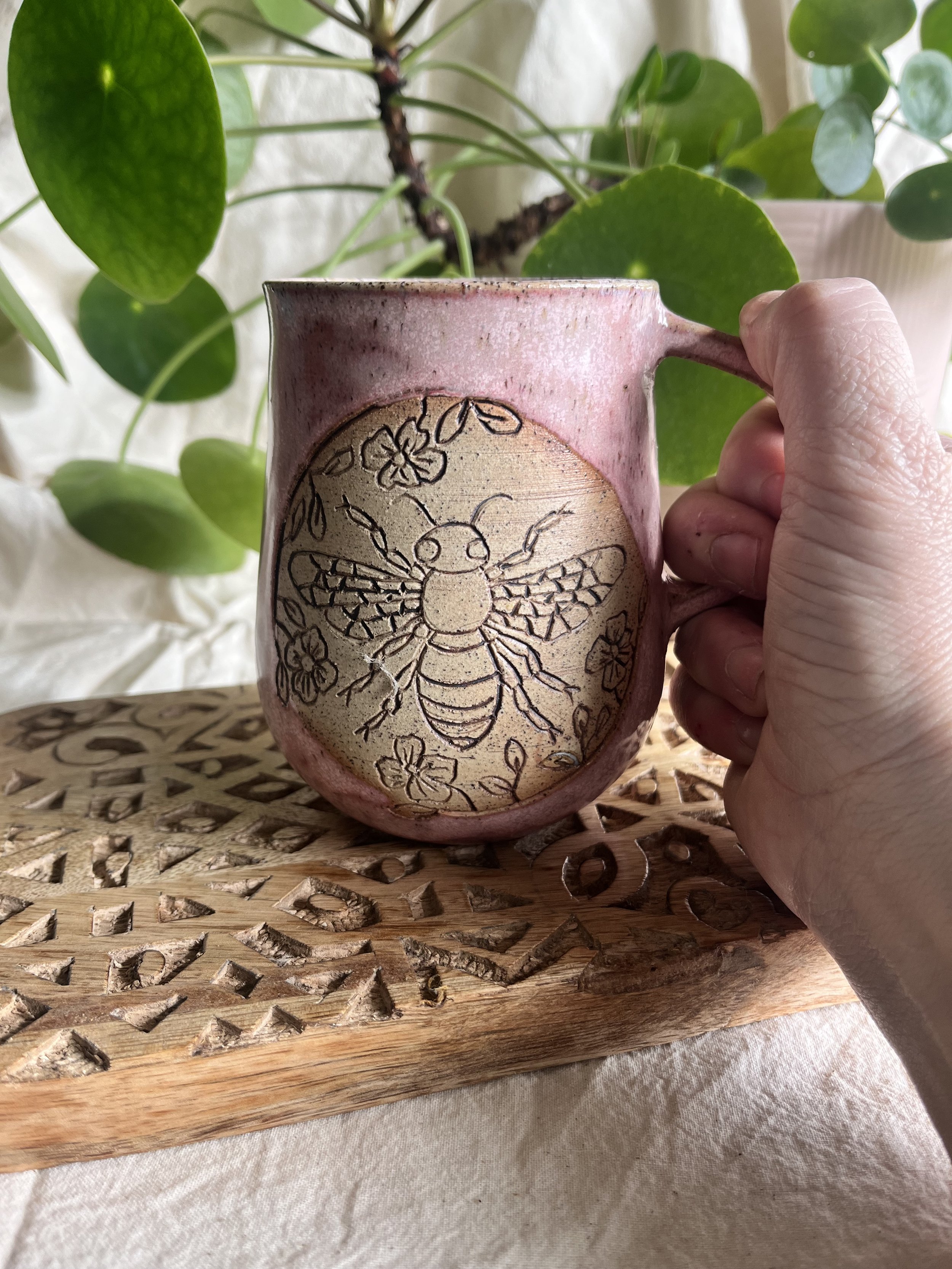 Pink bee mug in hand.jpeg