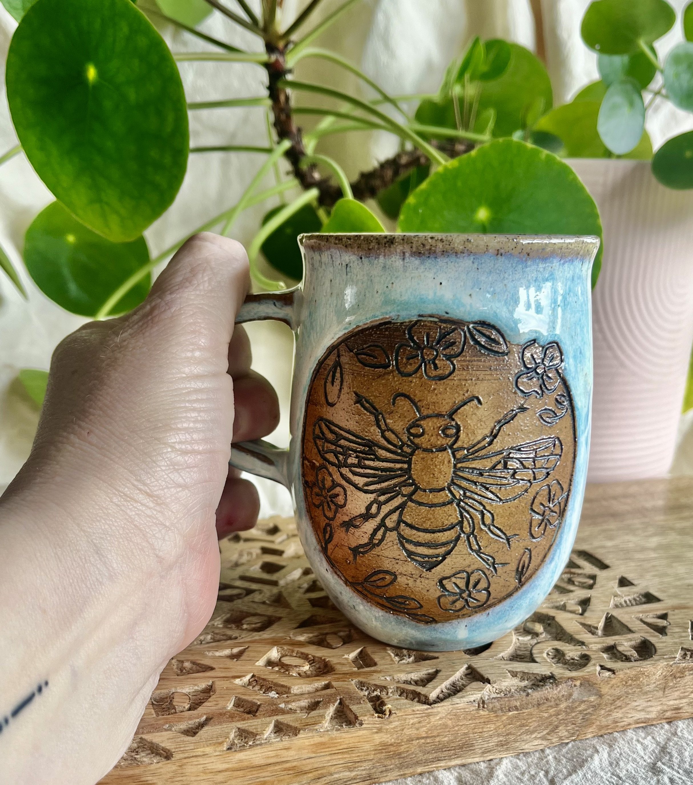 Light blue bee mug in hand view.jpeg