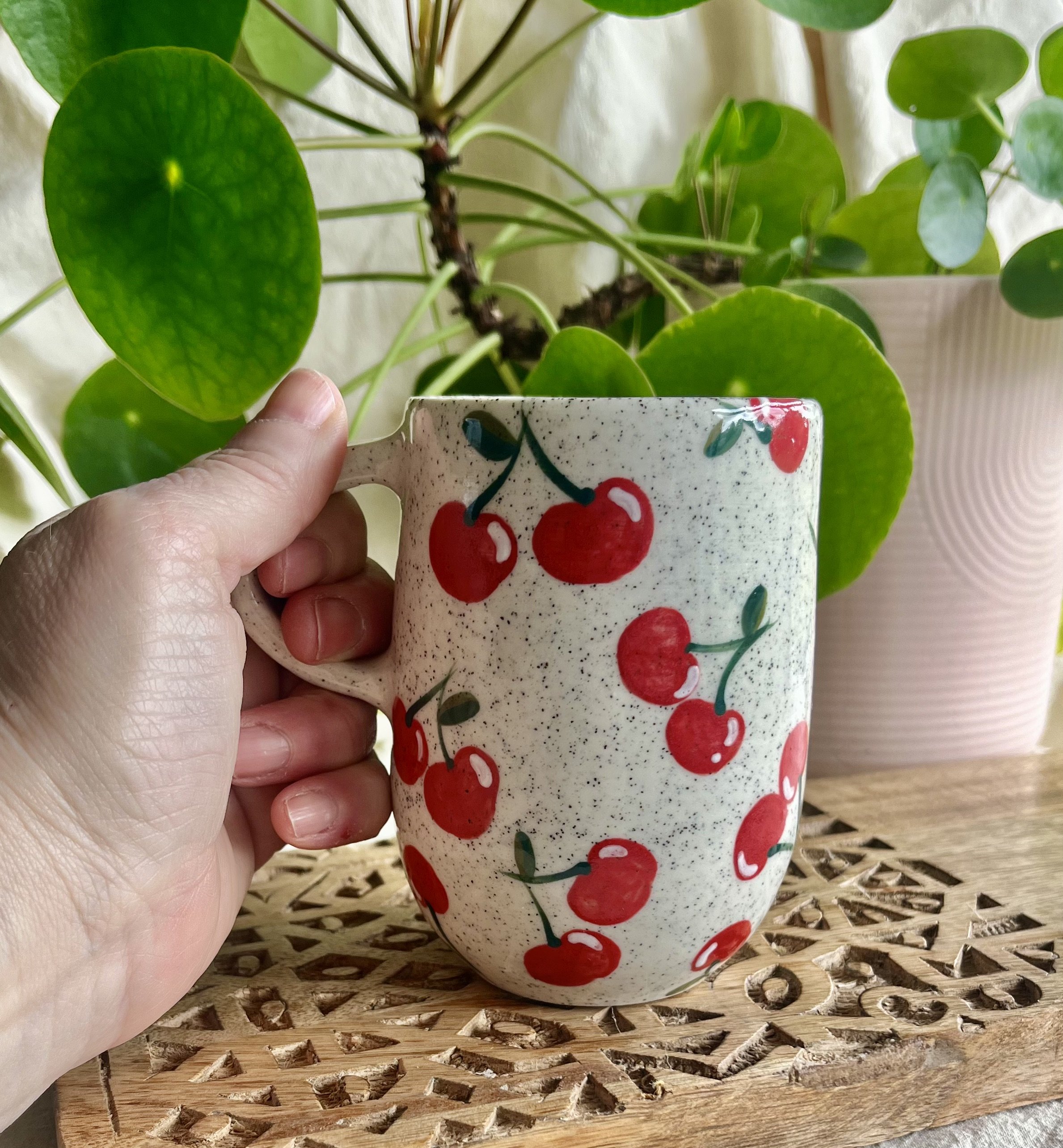 Cherry mug 1 in hand view.jpeg