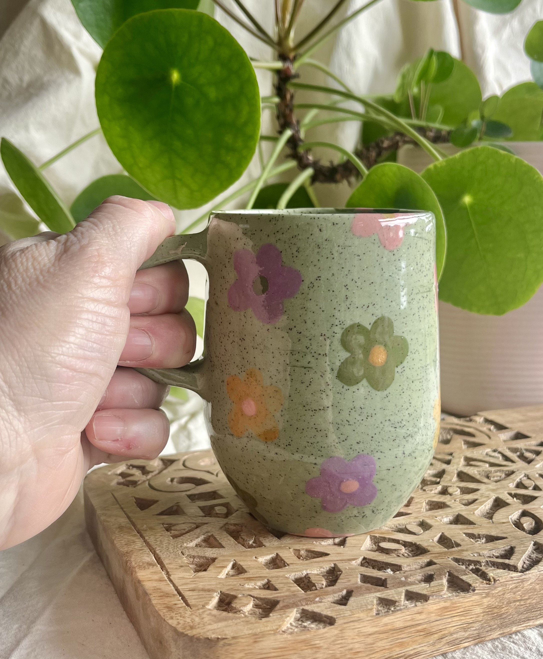 Green daisy mug in hand view.jpeg