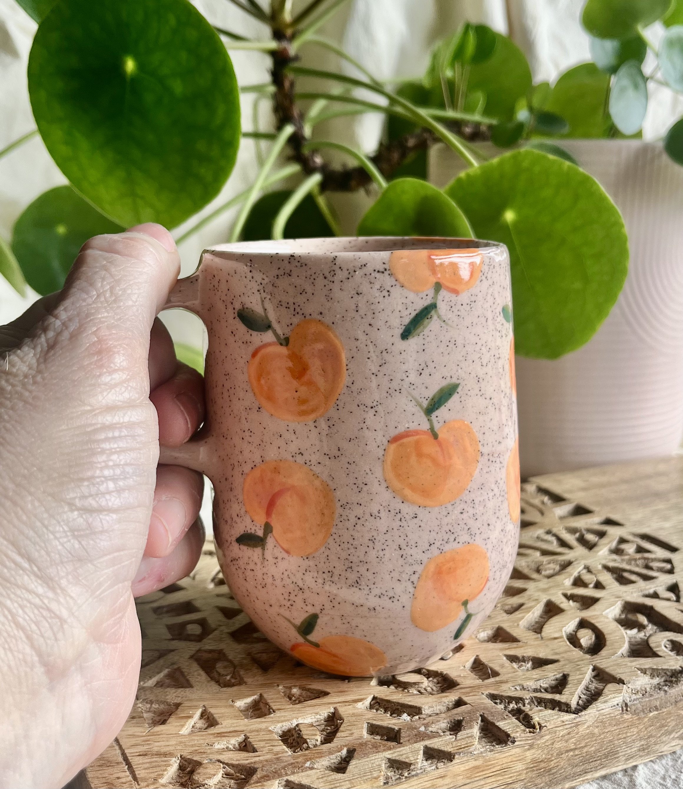 Pink peach mug in hand view.jpeg
