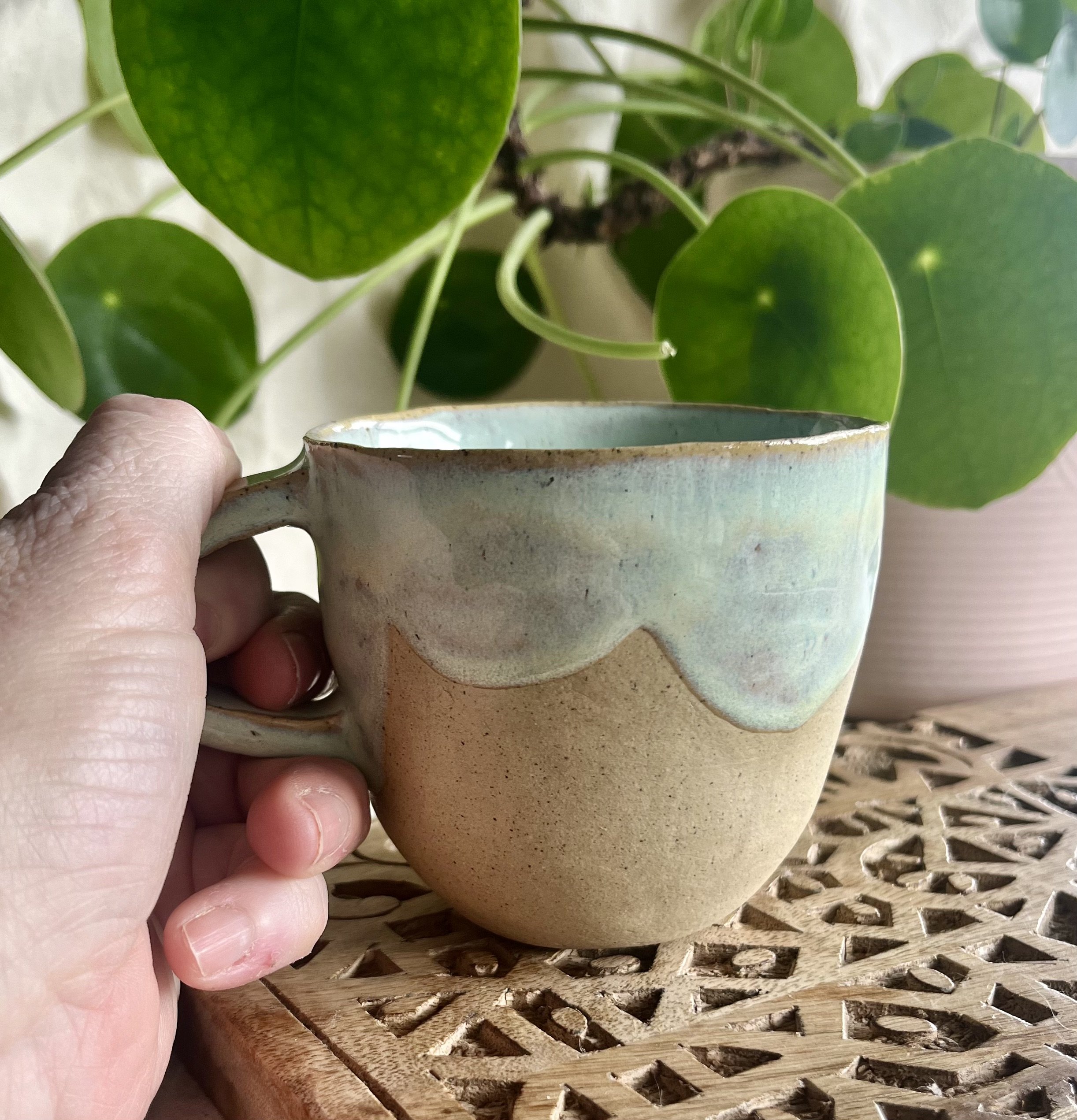 Light green scalloped mug in hand view.jpeg