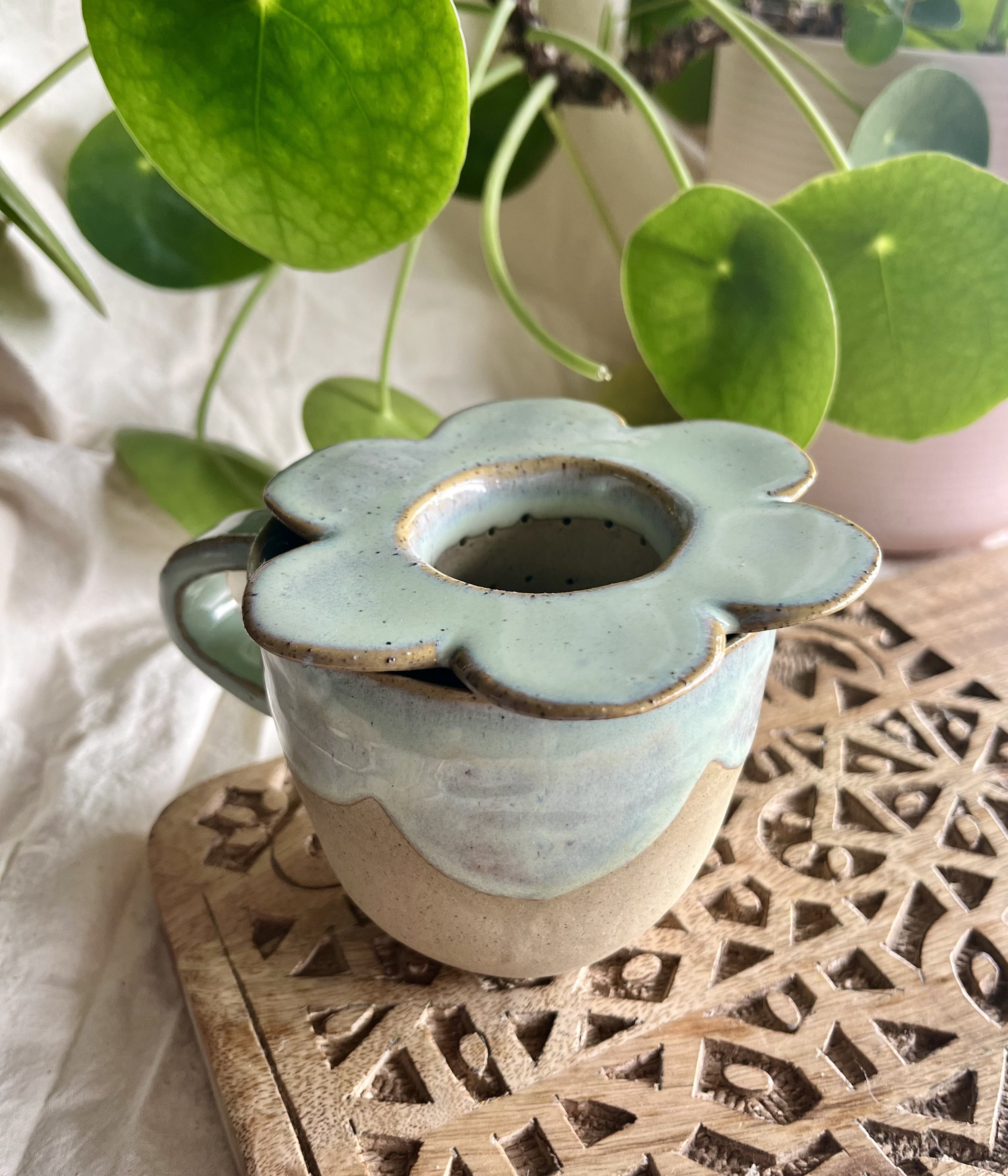 Light green scalloped mug with tea strainer inside.jpeg