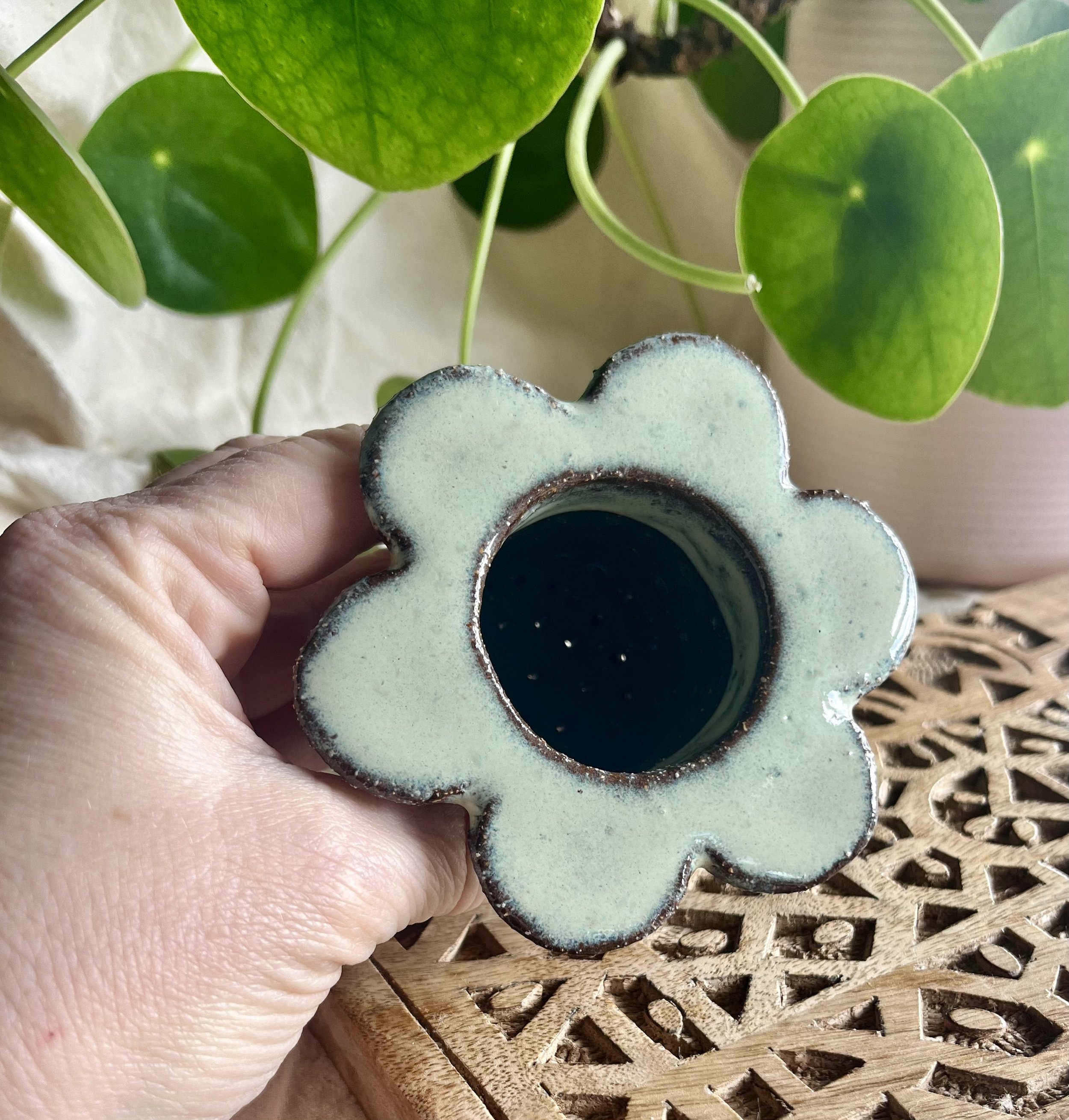Cream on dark matter flower tea strainer in hand.jpeg