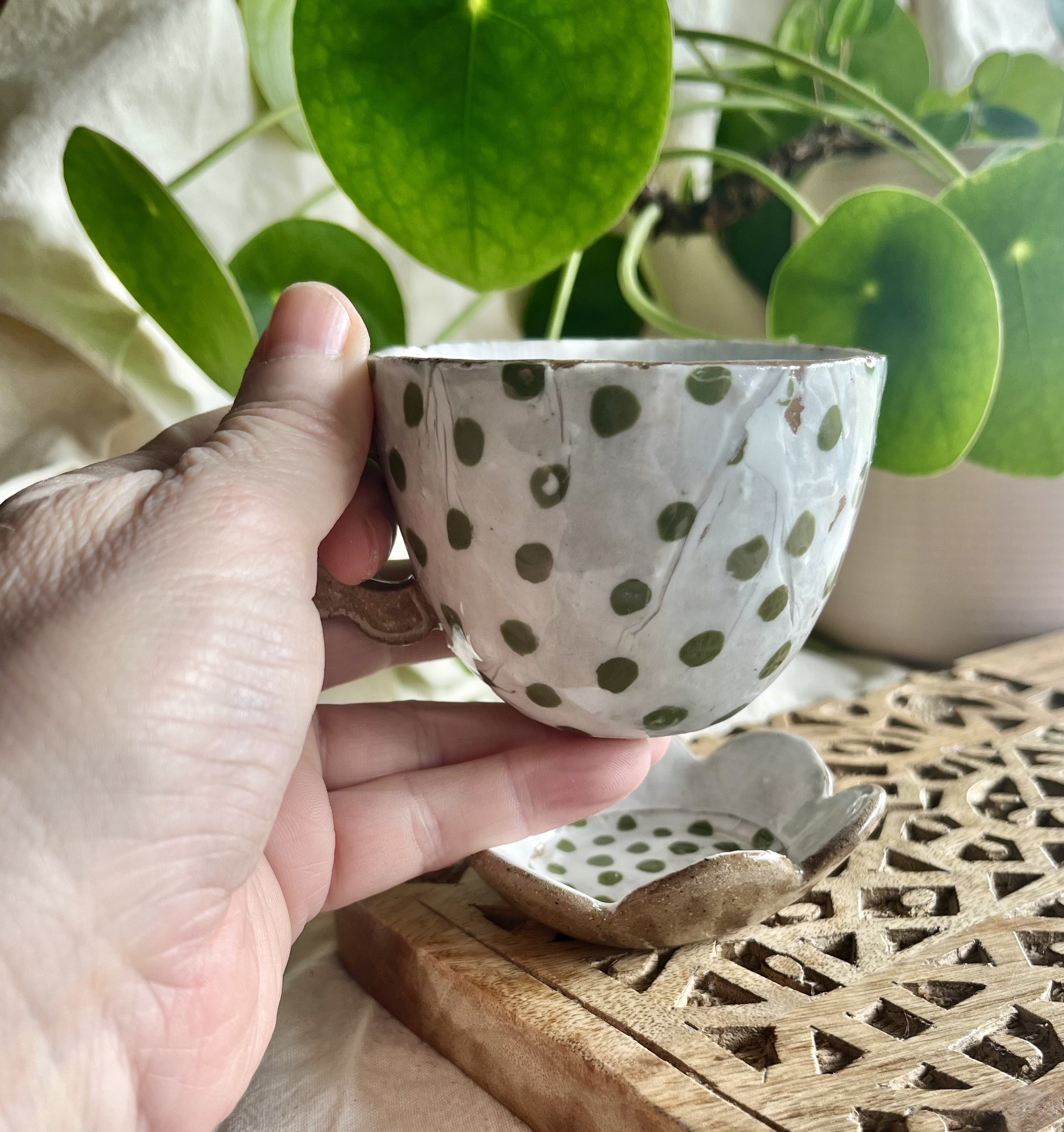 Green spotty espresso cup and saucer in hand view.jpeg