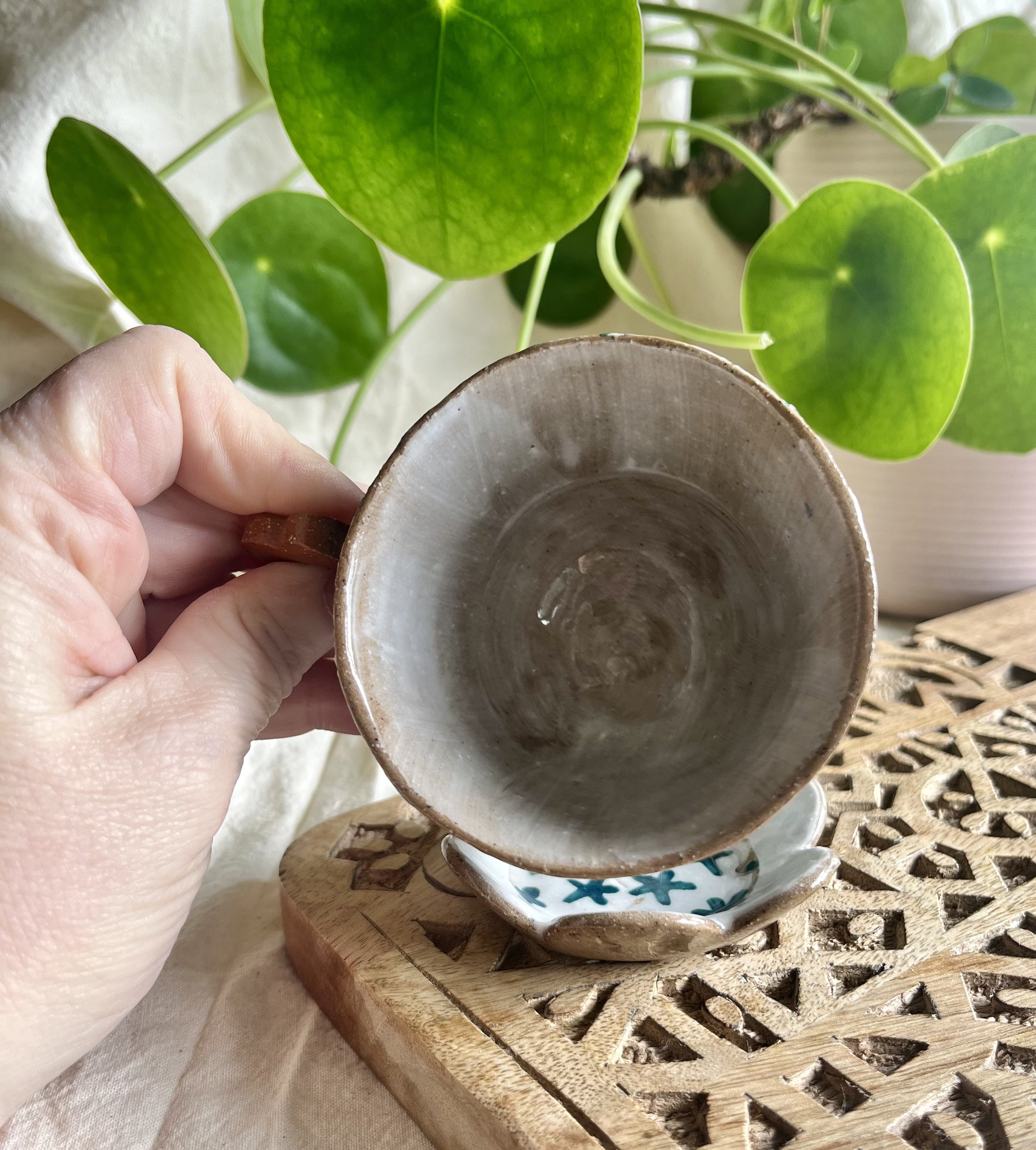 teal flower espresso cup and saucer in hand view.jpeg