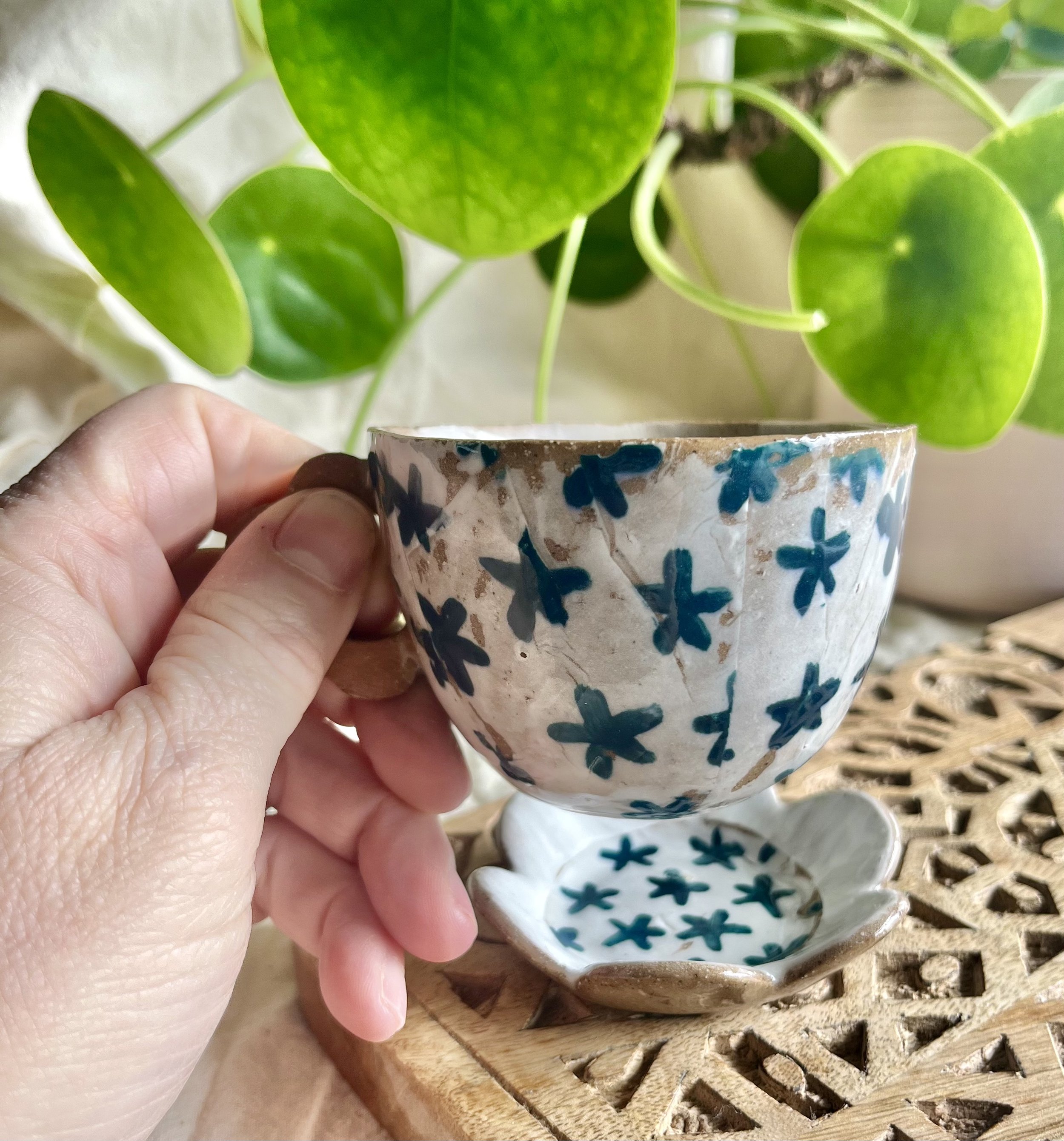 teal flower espresso cup and saucer in hand.jpeg