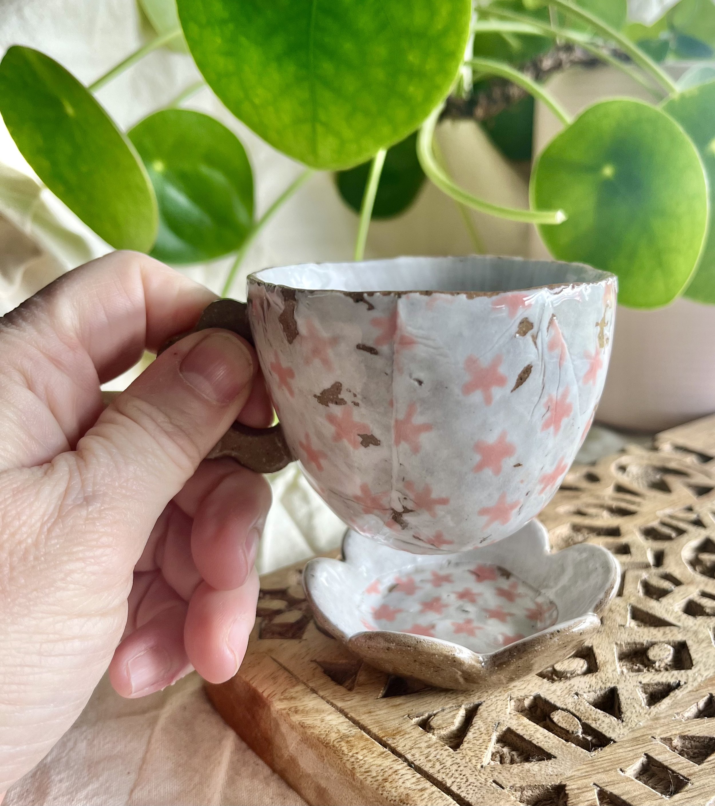 Pink flower espresso cup and saucer in hand view.jpeg