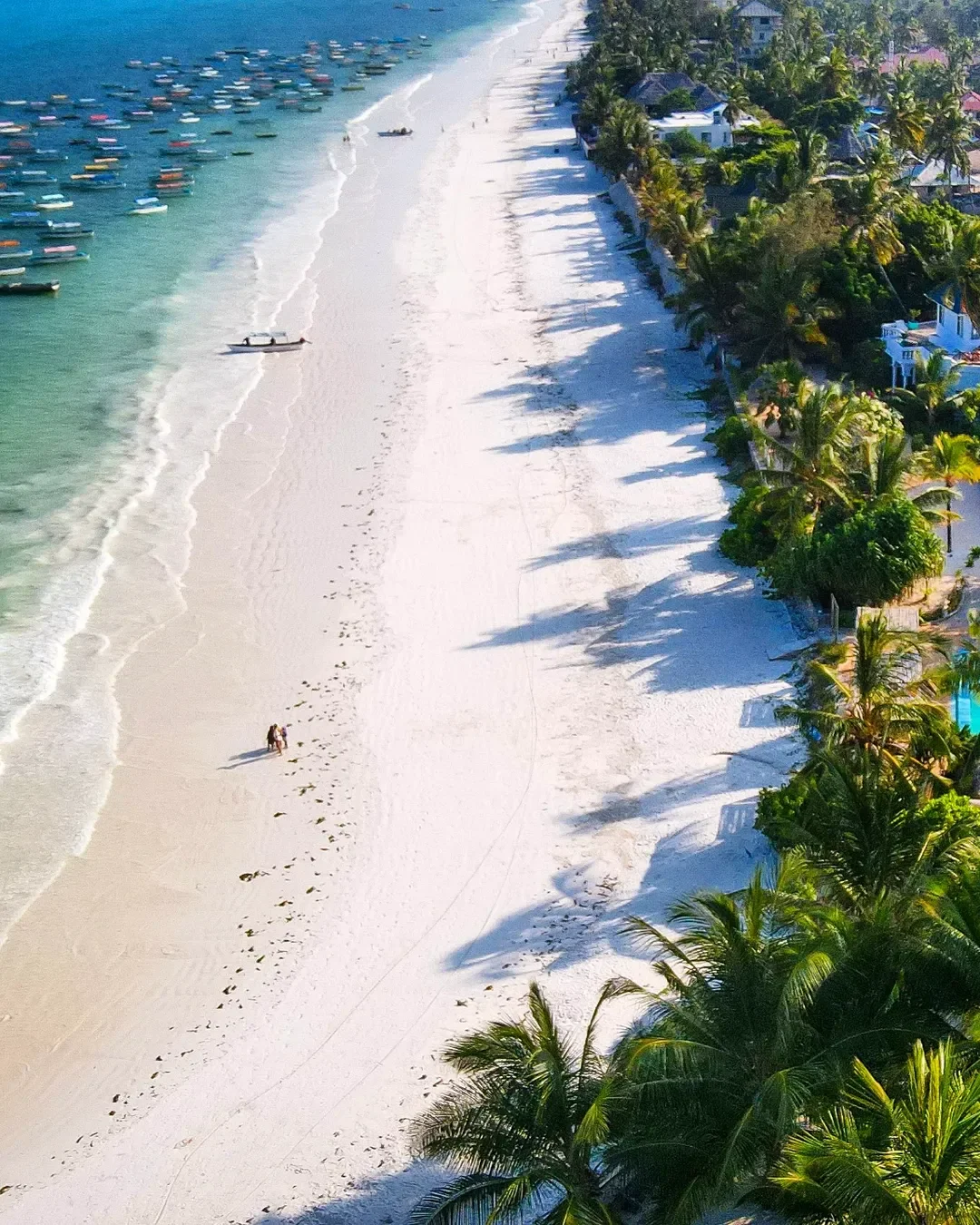 Pristine white sand at Matemwe Beach Zanzibar overlooking turquoise waters and Mnemba Atoll; a top destination for snorkeling and diving in Tanzania.