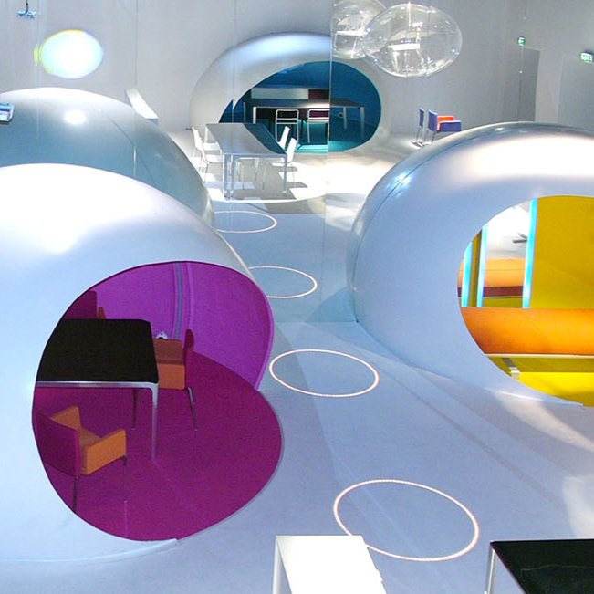 Siège haut dit HERMANO en aluminium avec une assise colorée d’un orange et violet vif imaginé par Mario Mazzer pour YCAMI pour le SALON DEL MOBILE de Milan en 2004.