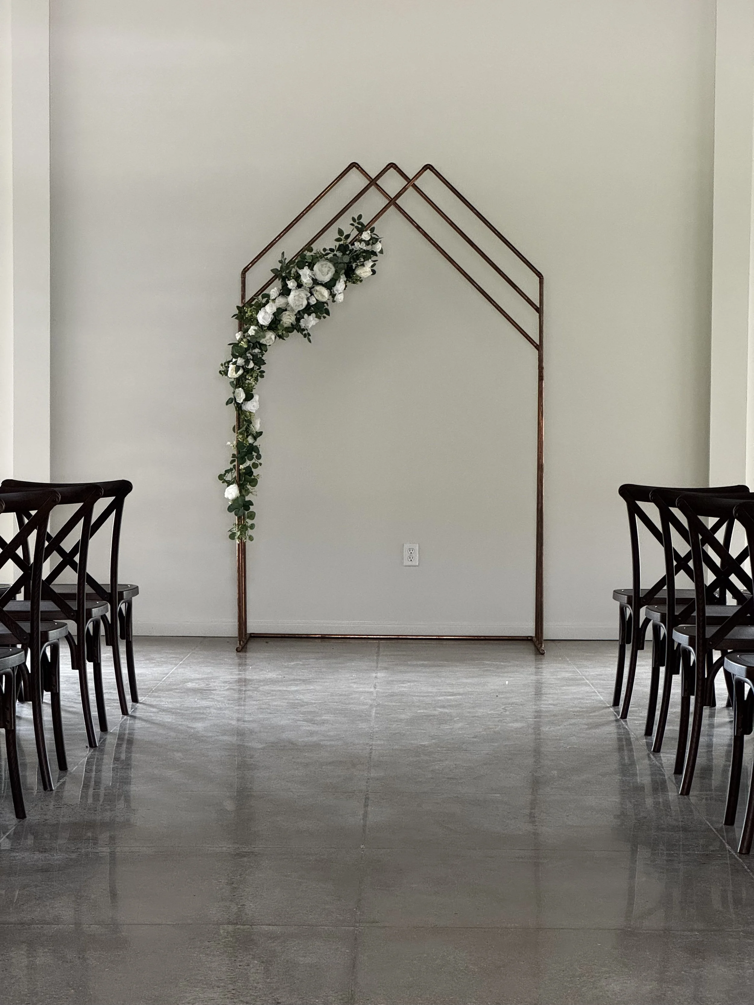 copper wedding arch decorated with neutral florals at all inclusive reception at Sawyers Cove Farm in Calera, Alabama