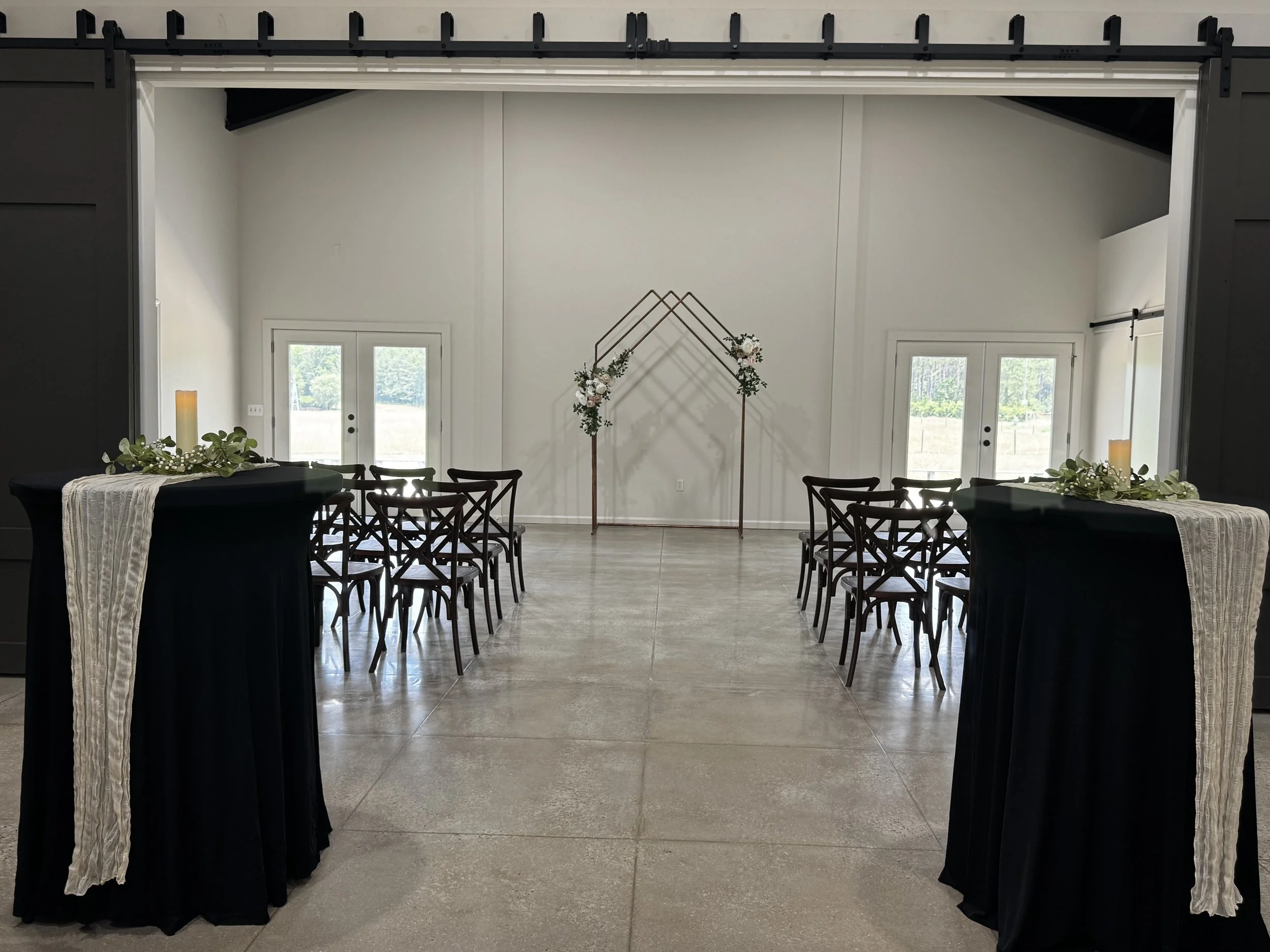 Wedding ceremony setup with floral arch and guest seating at Sawyers Cove Farm in Calera, Alabama.