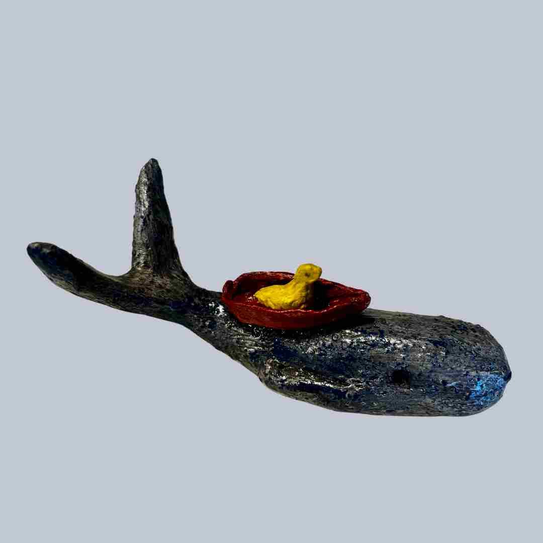 Anthea Taljaard - SaltSpray Design
Sculpture of a whale with a small yellow duck in a red boat on its back, against a gray background.
