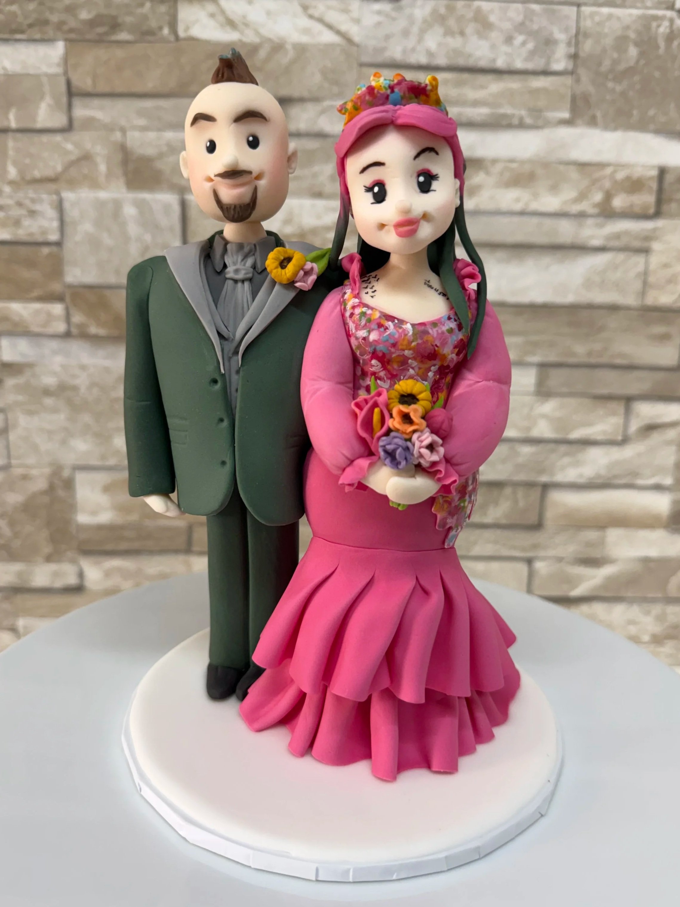 Alternative bride and groom wedding cake topper. Bride with dreadlocks and hot pink wedding dress, groom with mohawk and green suit