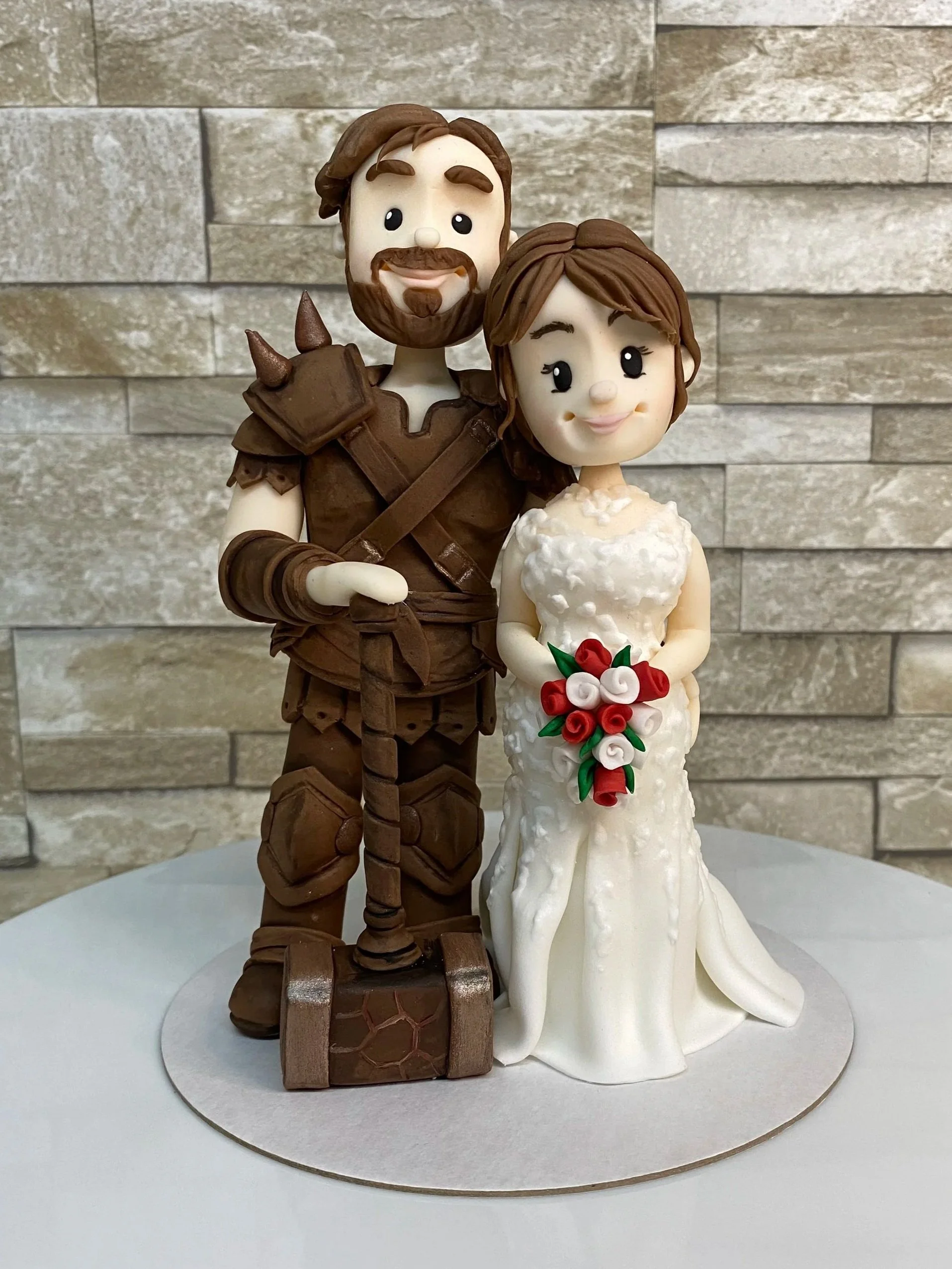 Bride and groom wedding cake figurine, groom dressed with a world of warcraft outfit with hammer, bride in a traditional white wedding dress 