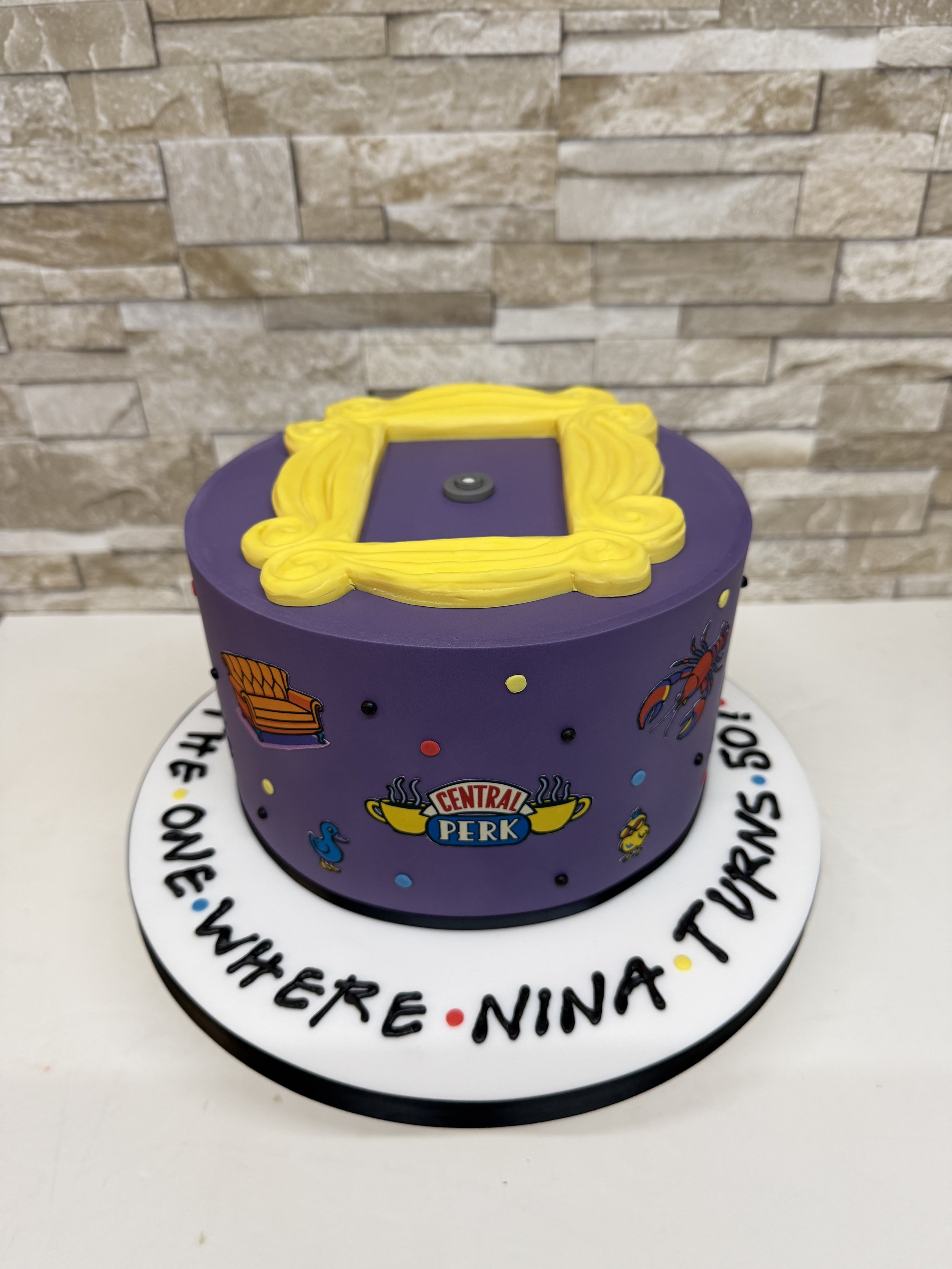 Single tier purple birthday cake with a 'friends' theme