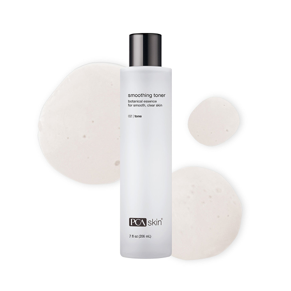 A white bottle of PCA skin smoothing toner with a black cap, surrounded by three white cotton pads on a white background.