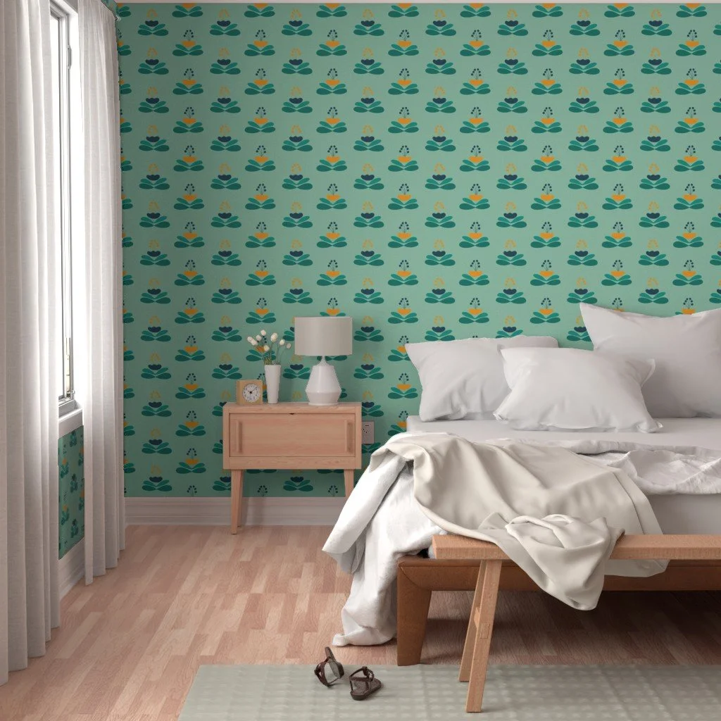 A bedroom with a teal and yellow patterned accent wall, a bed with white pillows and bedding, a wooden nightstand with a lamp, clock, and plant, and a pair of sandals on the floor.
