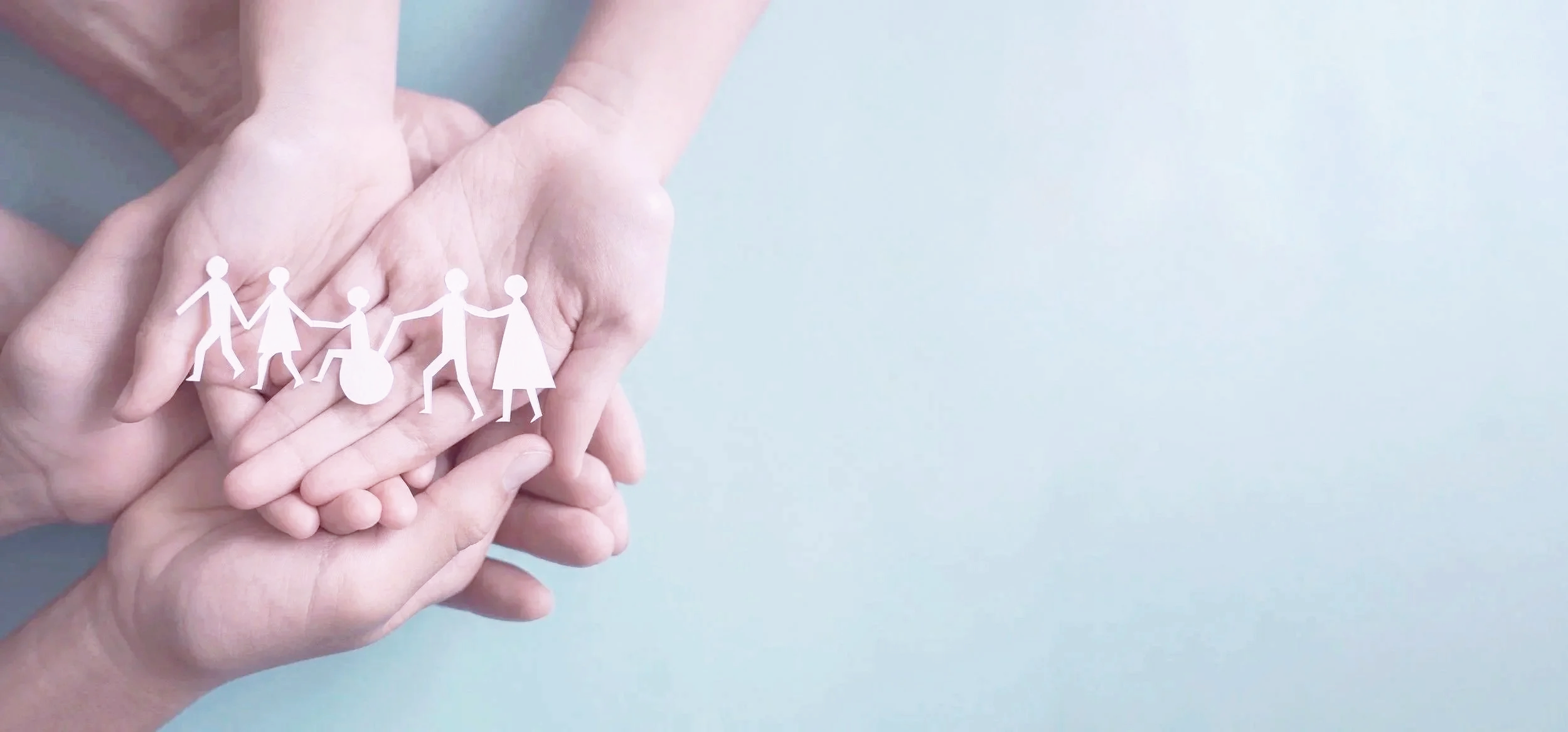 Two pairs of hands holding paper cutouts of people representing areas of Mindful Mind counselling work.