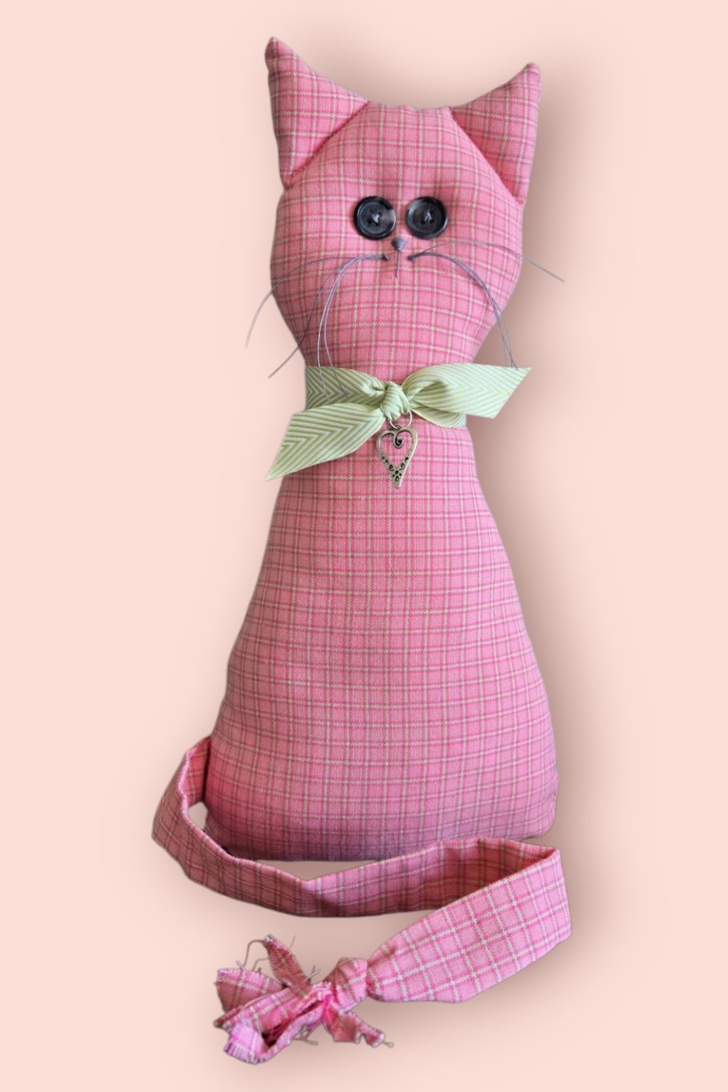 Handmade cat made with pink and green plain cotton, a green neck ribbon and silver heart charm. Doll is 12 inches tall, with a 14 inch long tail.