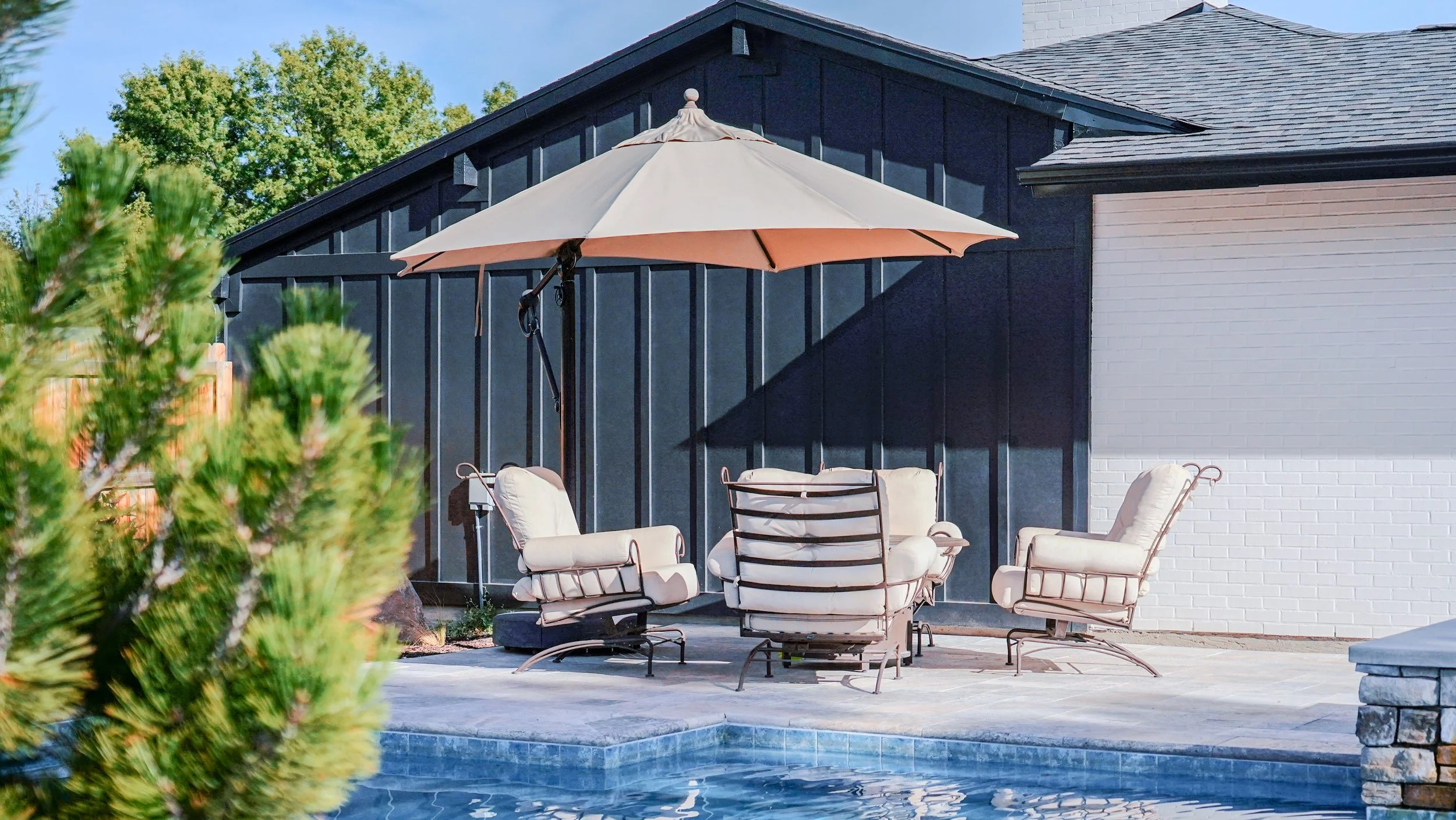 Backyard living space with black siding of the garage exposed into the backyard
