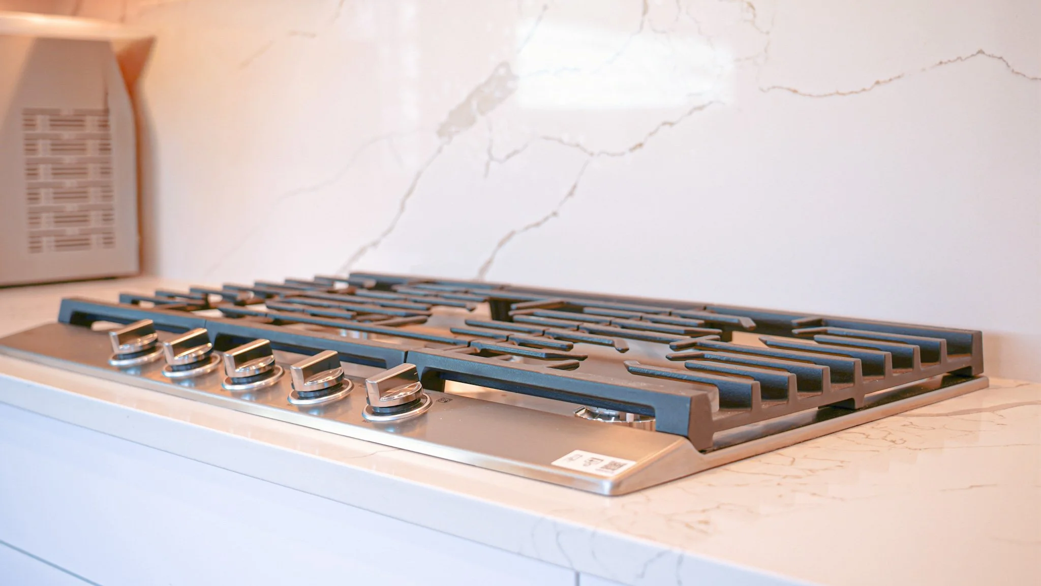 Built in stainless steel cooktop on granite countertops with granite backsplash walls