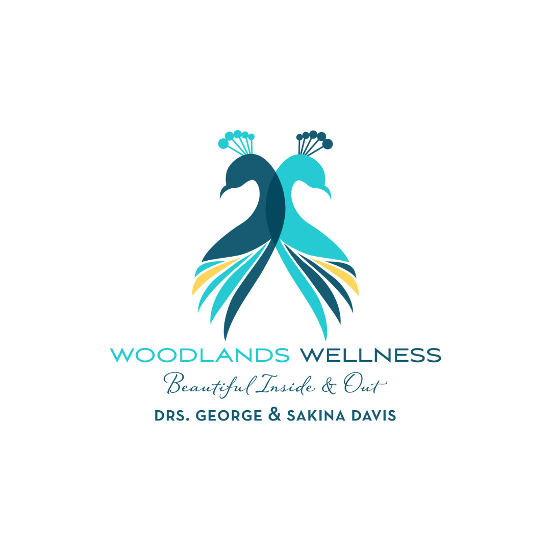 Logo for Woodlands Wellness featuring stylized two peacocks facing away, with blue and teal feathers, accompanied by text: 'Woodlands Wellness, Beautiful Inside & Out, Drs. George & Sakina Davis'.
