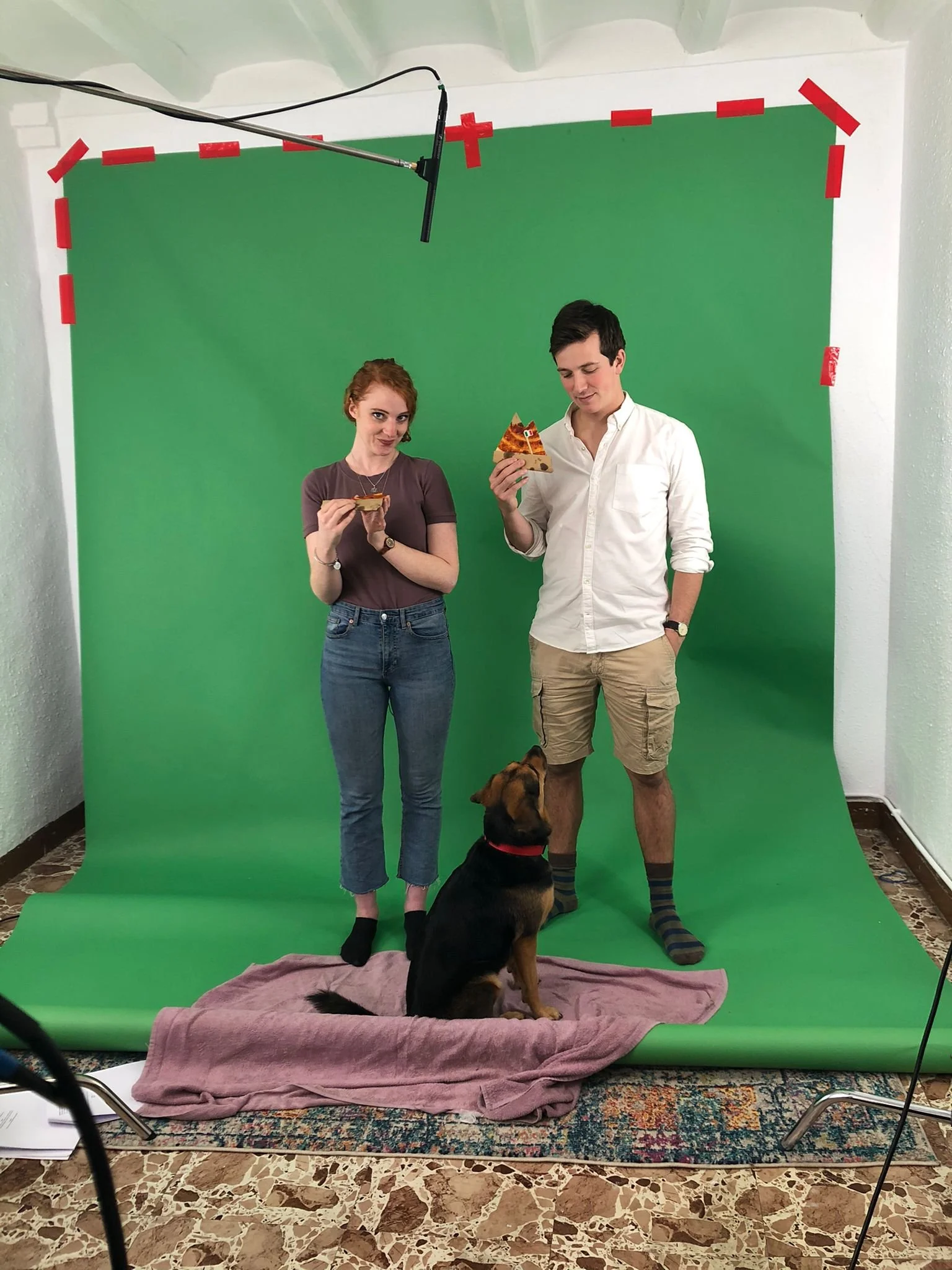 Two actors with a pizza and a dog. 