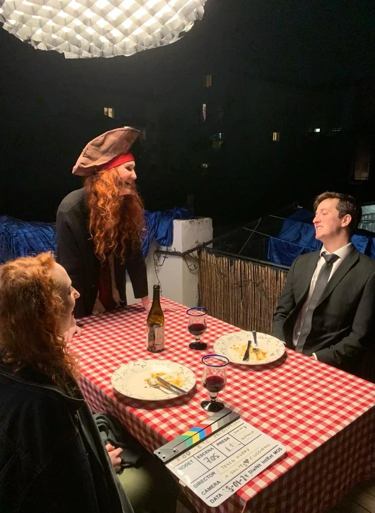 Two women and one man. Filming a dinner with a pirate hat. 
