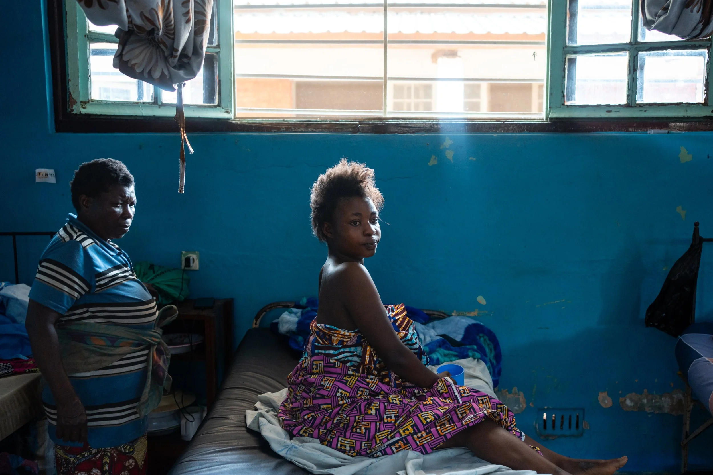 Annifa, 20, and her mother Sifa, at the Bukavu Hospital. "I was at home when a stray bullet hit me," says Annifa. Bukavu, February 18, 2025.