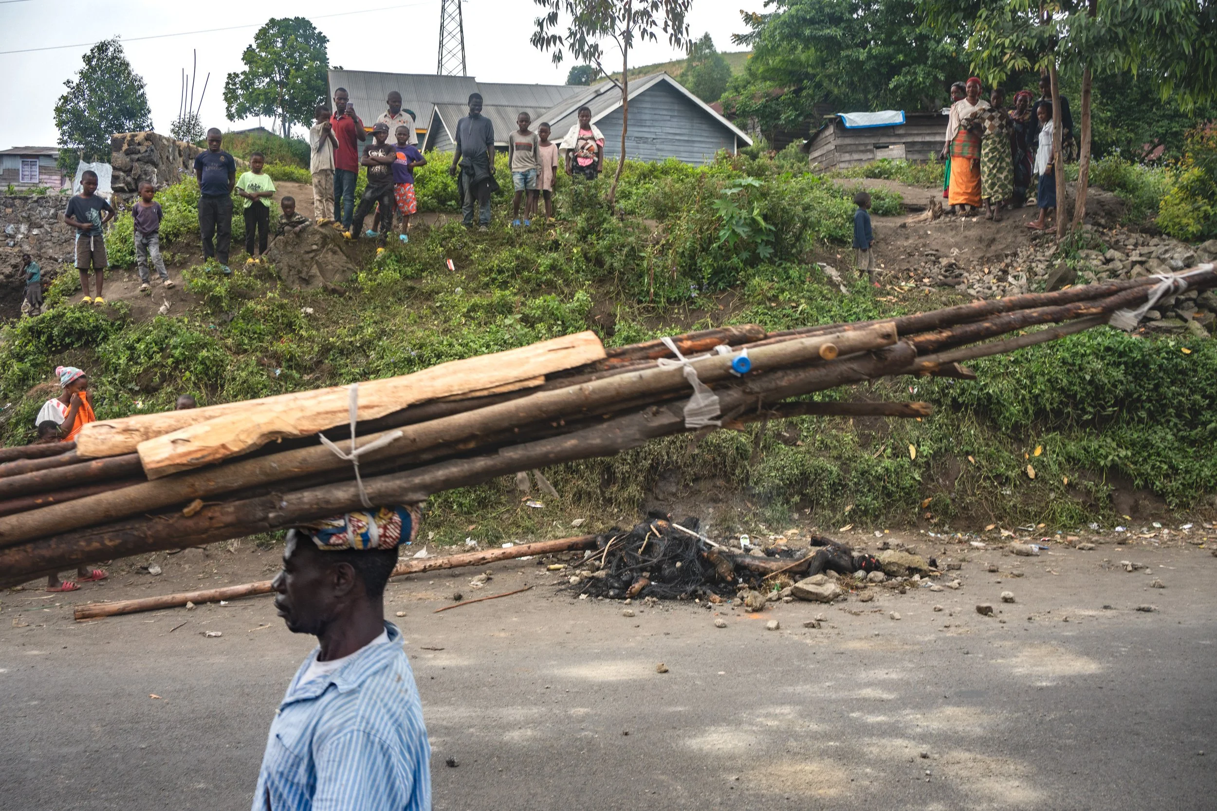 Three bodies burn at the side of a road on the outskirts of Goma. Accused of being bandits, mob justice is common since the M23 took the city. Goma, February 12, 2025.