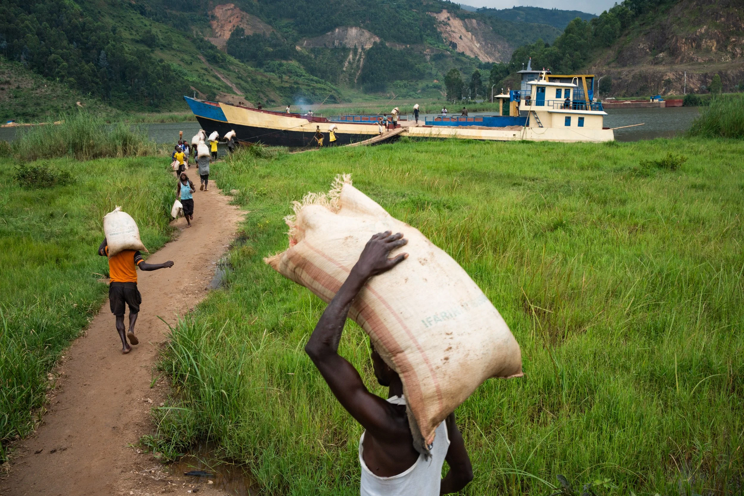 Workers load a boat with sacks of sand extracted from a river in Gishyita. Although Rwanda’s poverty rate dropped from 75.2 % to 53.5 % between 2000 and 2013, it has remained
almost stagnant since, according to World Bank data. 