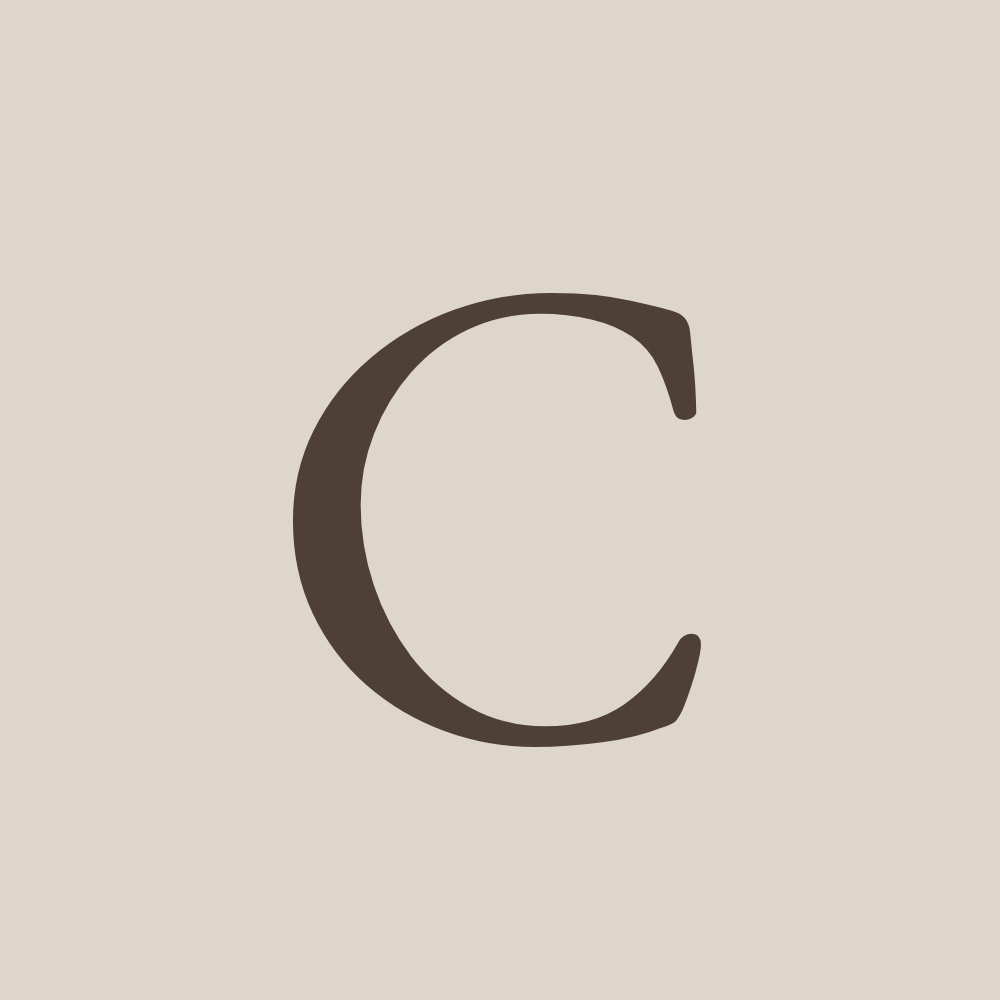 Close-up of the letter C on a beige background.